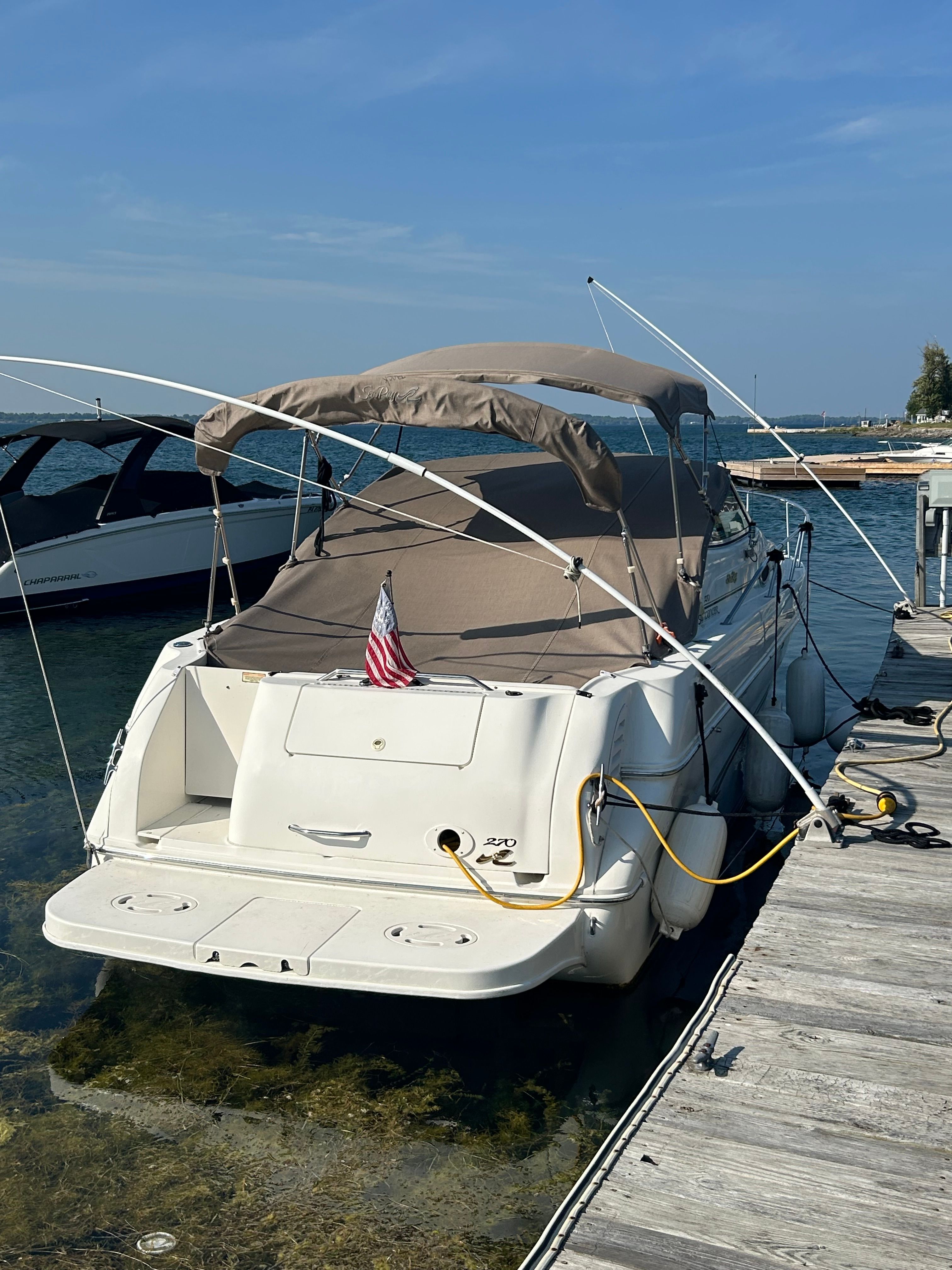 A 1999 Sea Ray 270 Sundancer Special Edition docked in clear water.