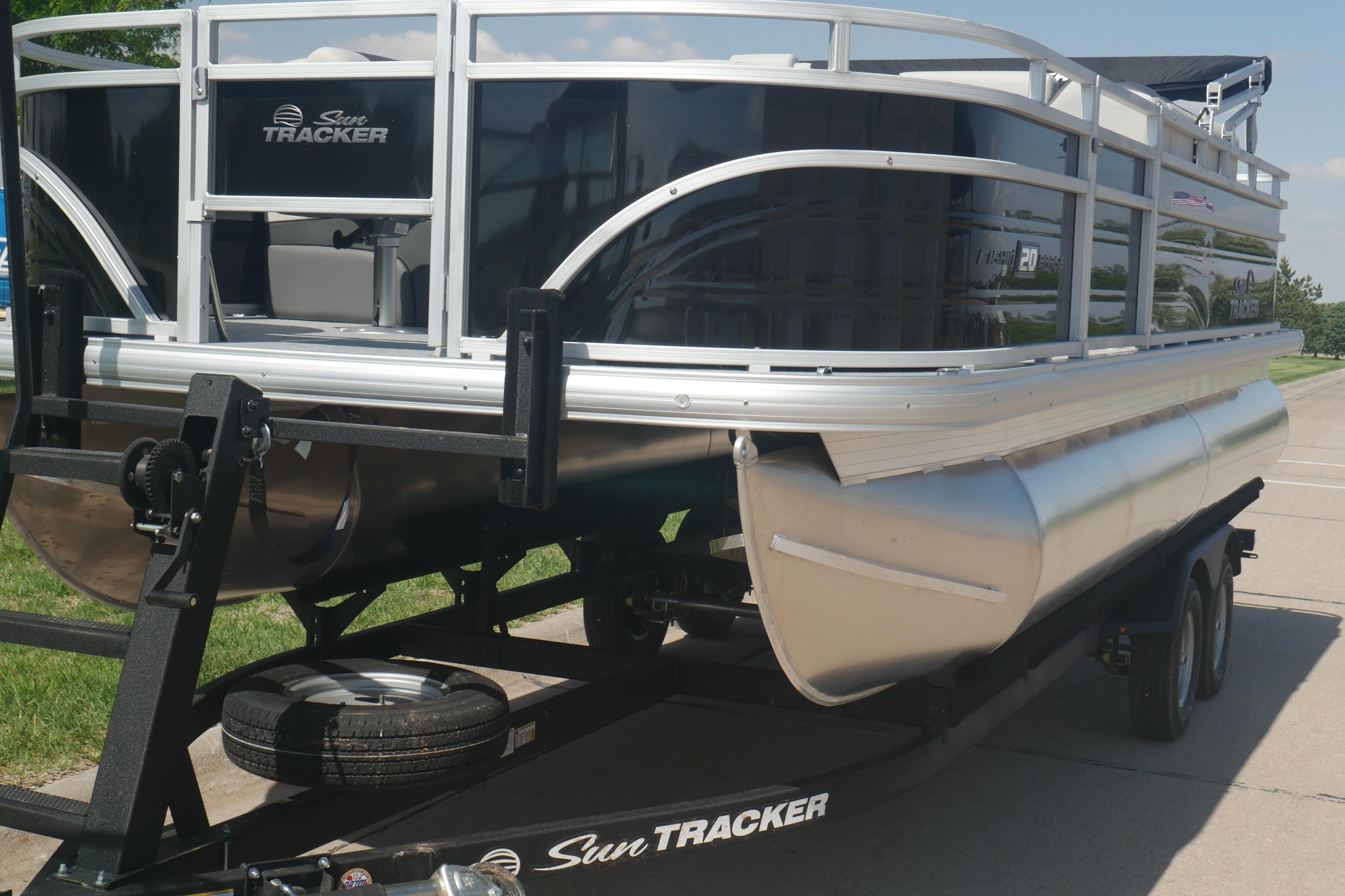 2026 Sun Tracker Fishin' Barge 20 DLX pontoon boat on trailer, side view.
