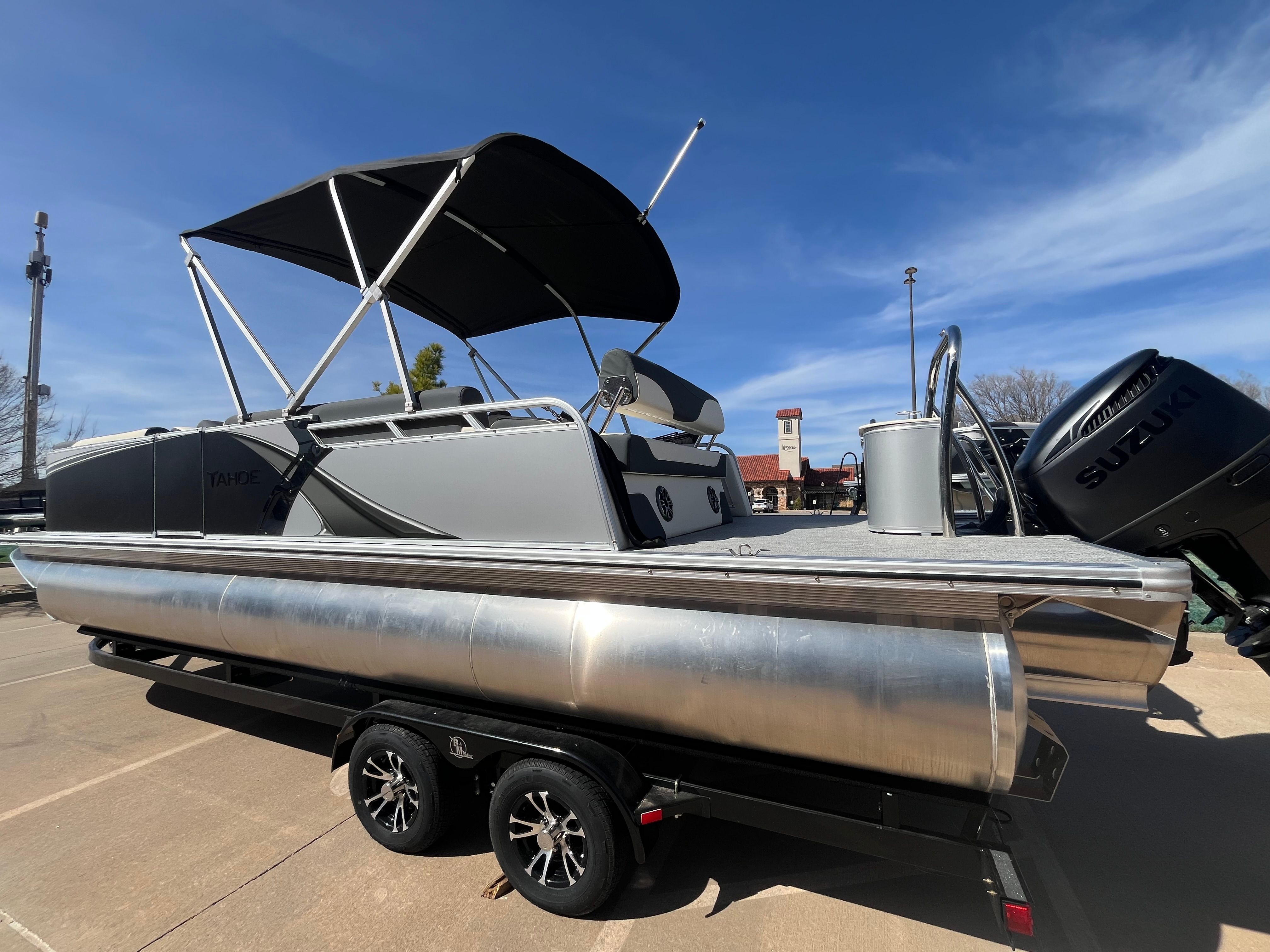 2026 Tahoe 2385 LTZ Cruise pontoon boat with Suzuki engine, on trailer.