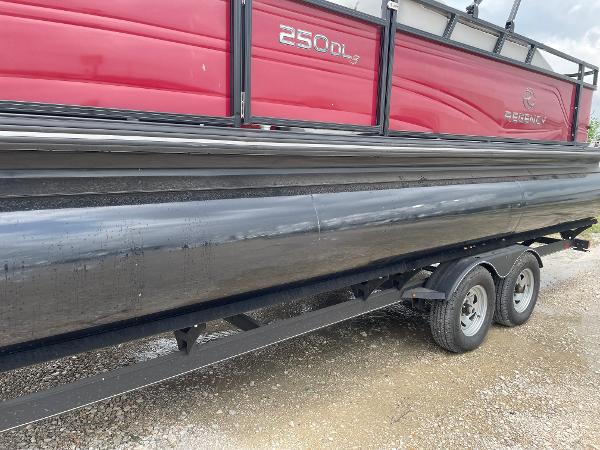 2023 Regency 250DL3 pontoon boat on trailer, featuring red and black design.