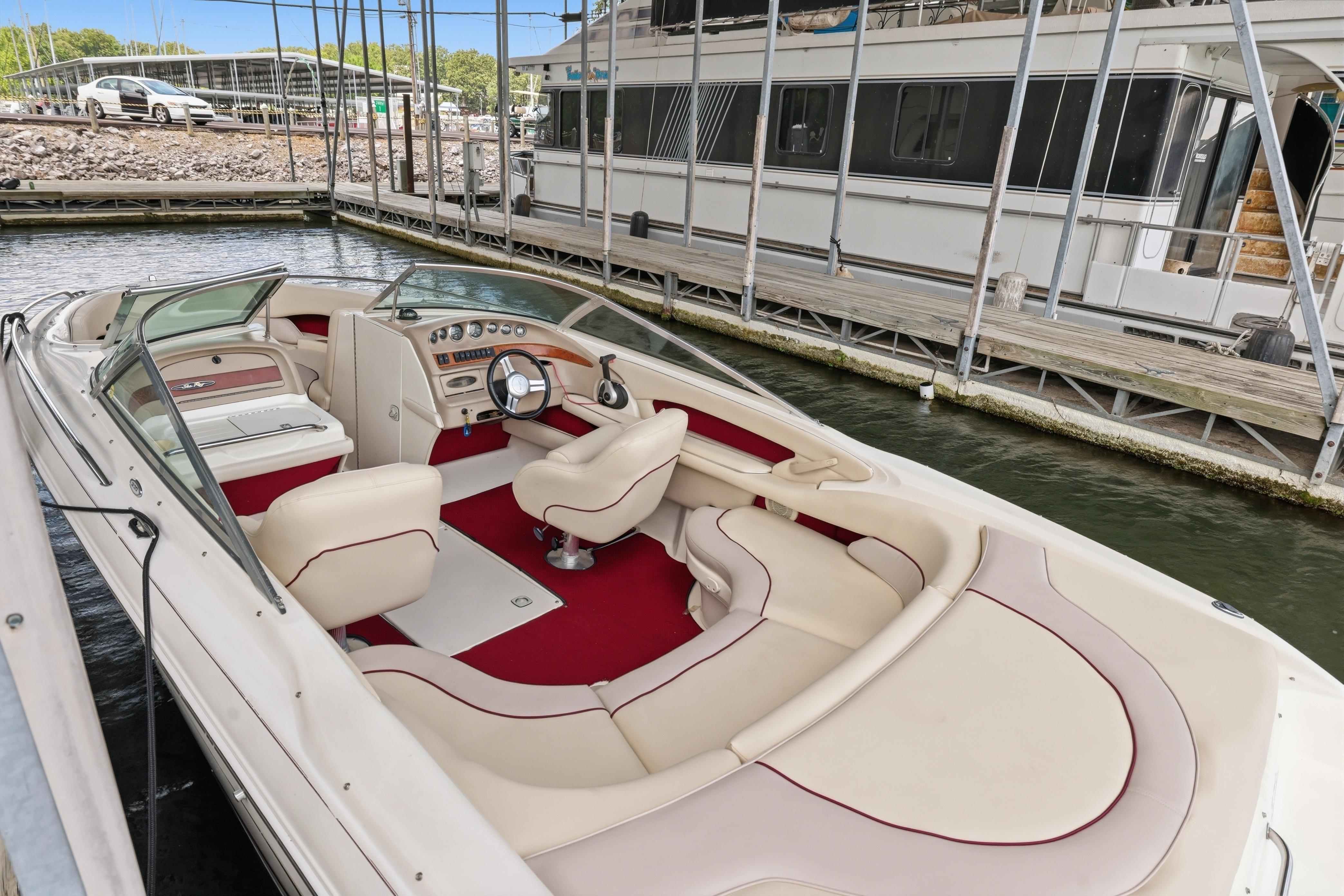 1997 Sea Ray 230 Signature boat with beige and red interior docked at marina.