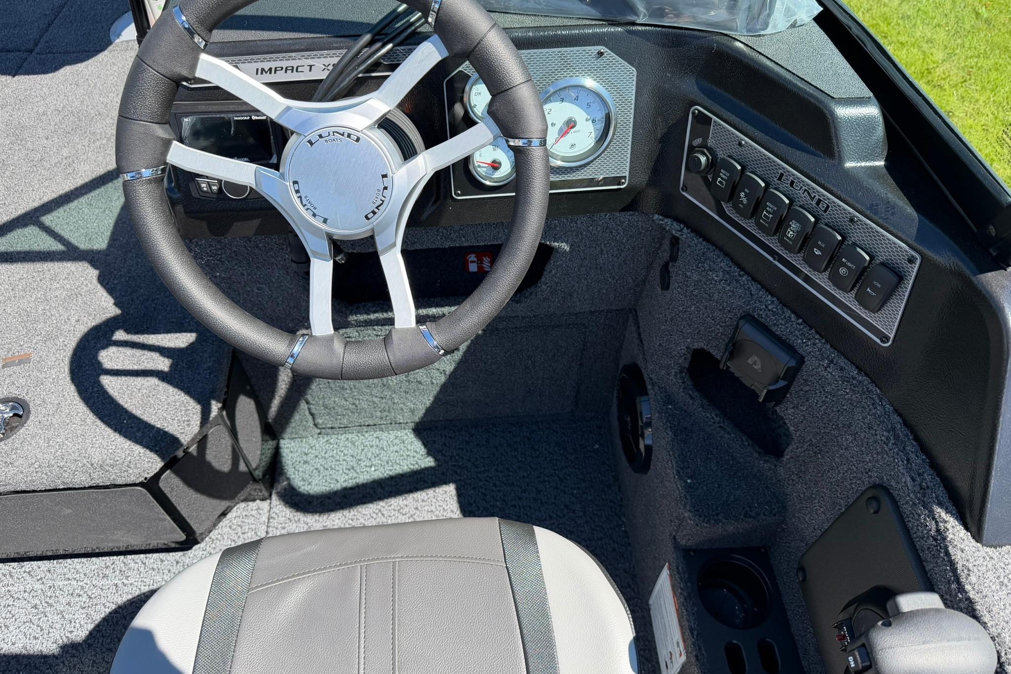 2027 Lund 1775 Impact XS Sport boat dashboard with steering wheel and control panel.