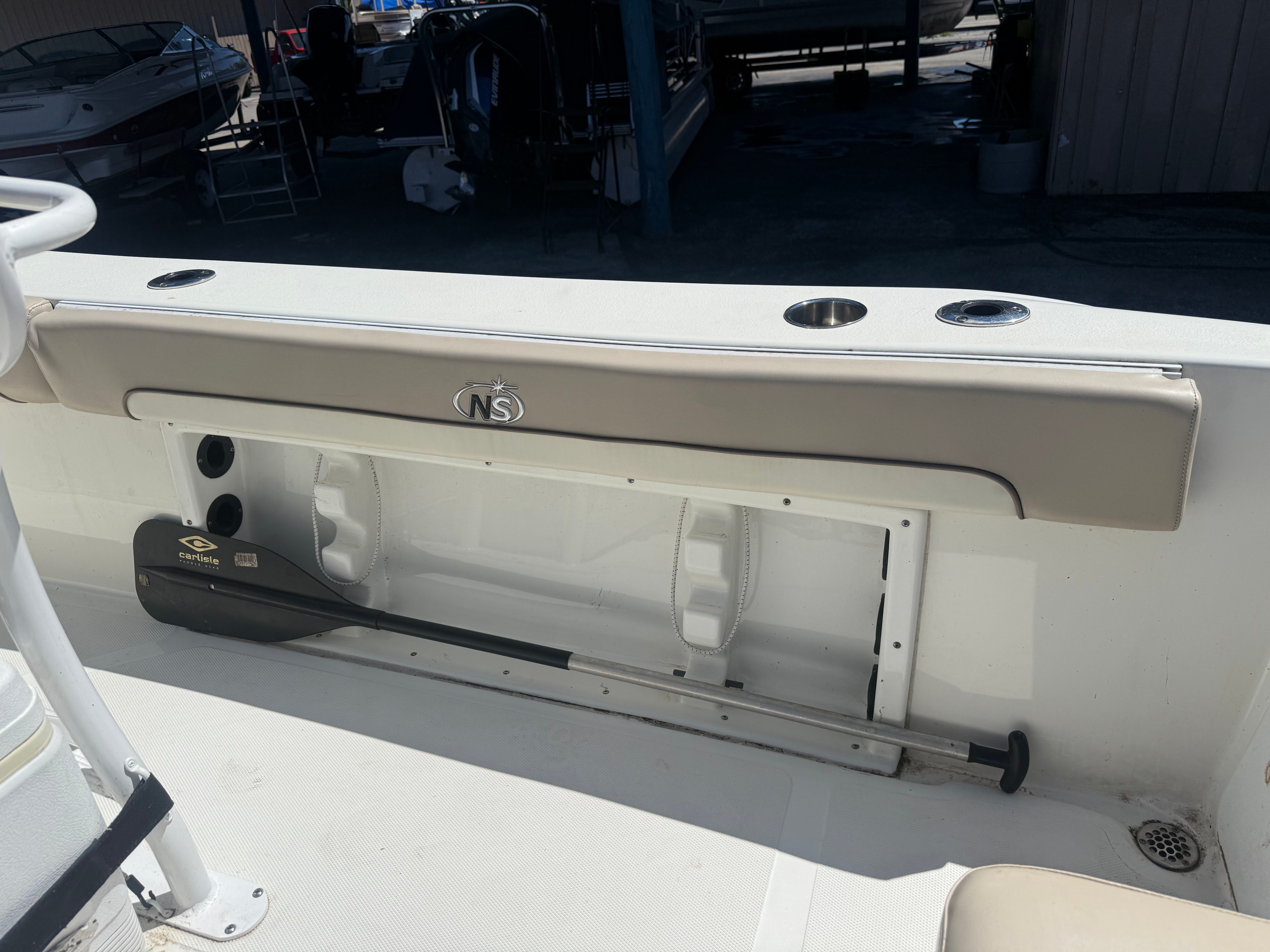 The image shows the interior of a NauticStar 22 XS boat with storage and a paddle.