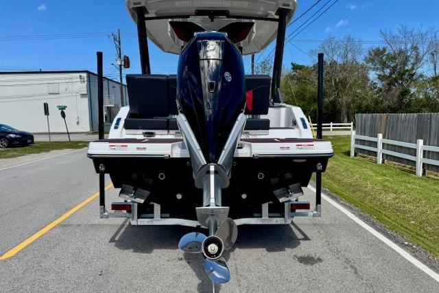 2026 Monterey Elite 25 OB boat with outboard motor on a trailer, parked on a street.