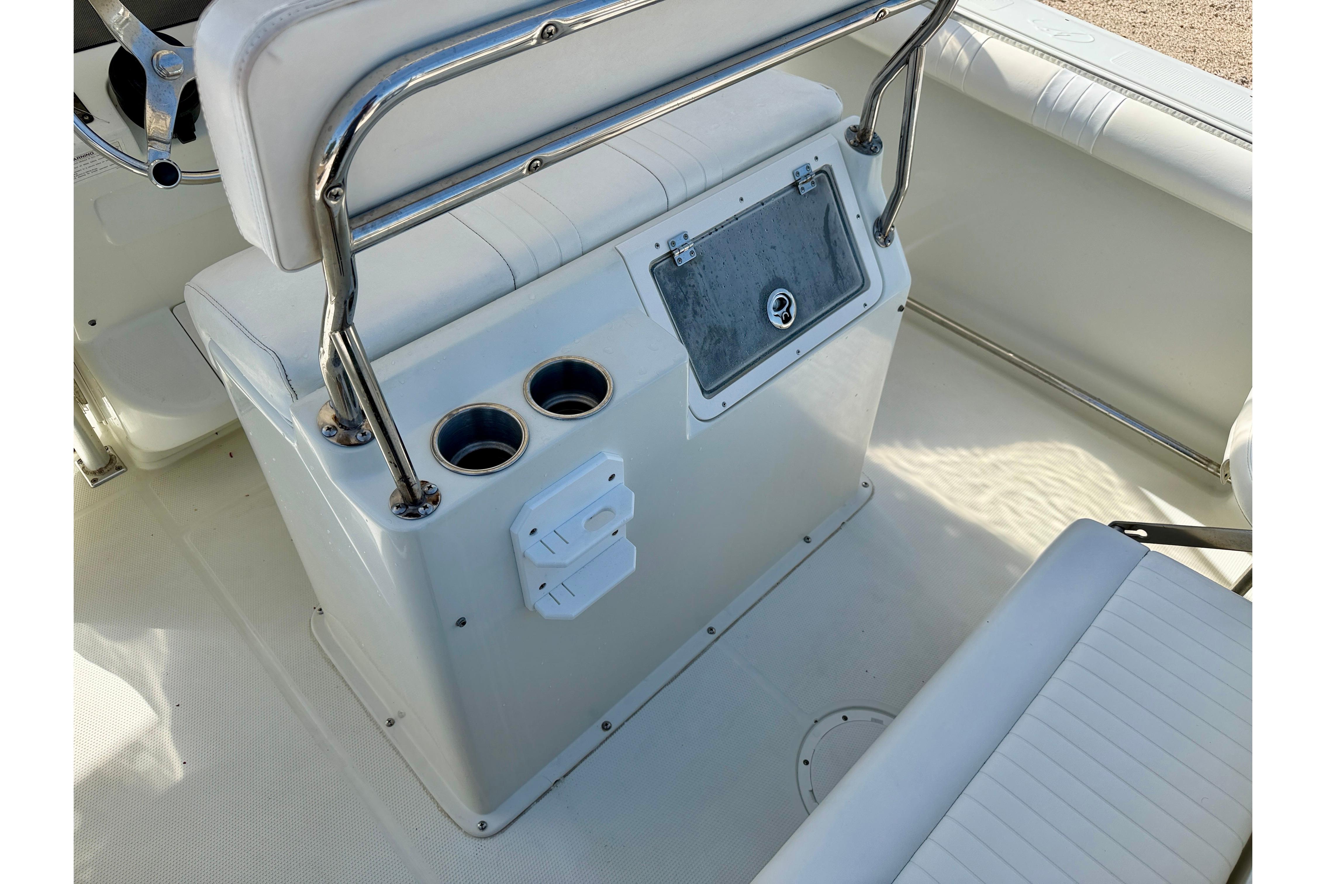 2006 Sailfish 2360 CC boat interior with seating, cup holders, and storage compartment.