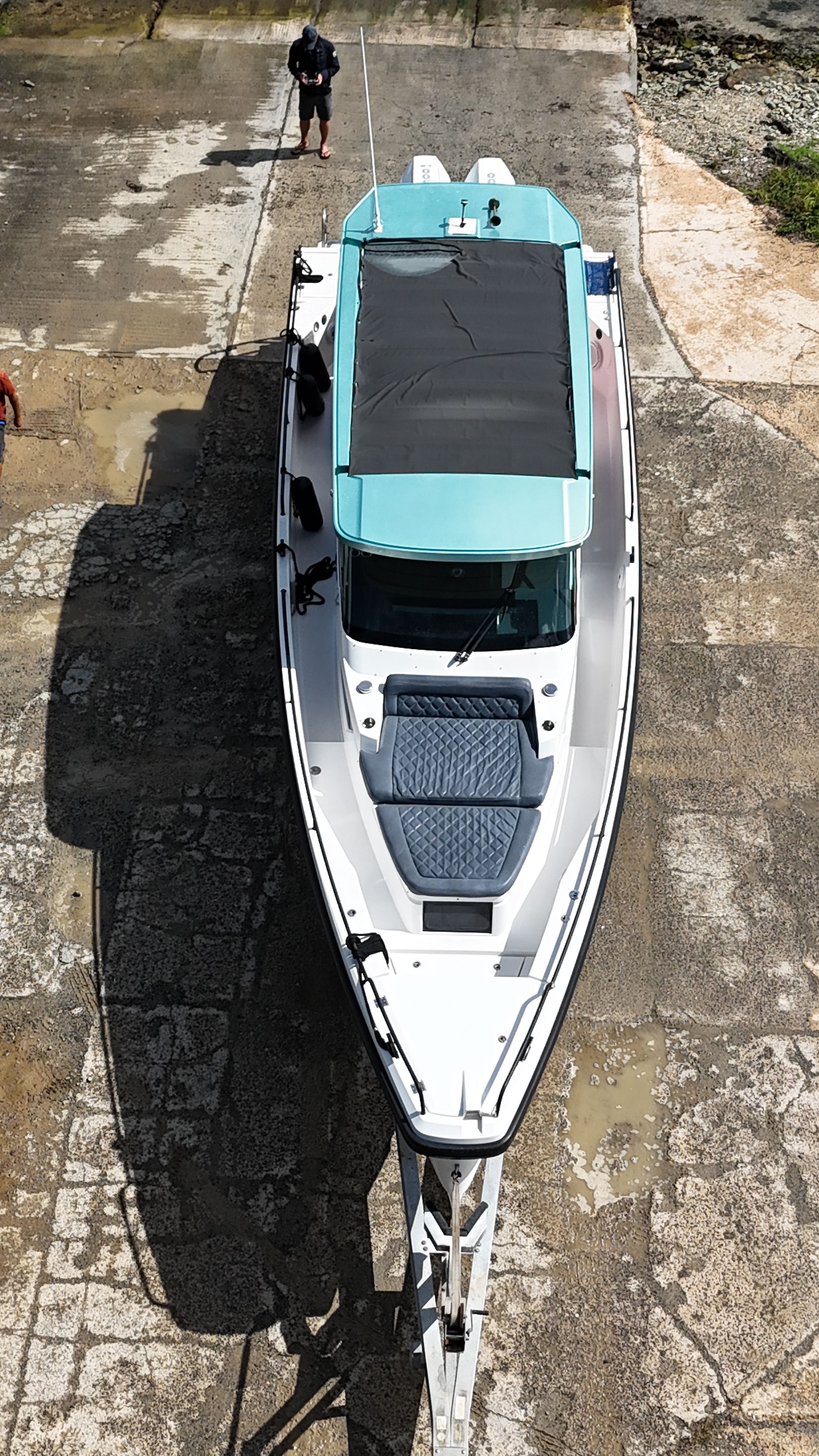 Aerial view of an Axopar 37 SUN TOP boat on a concrete surface.