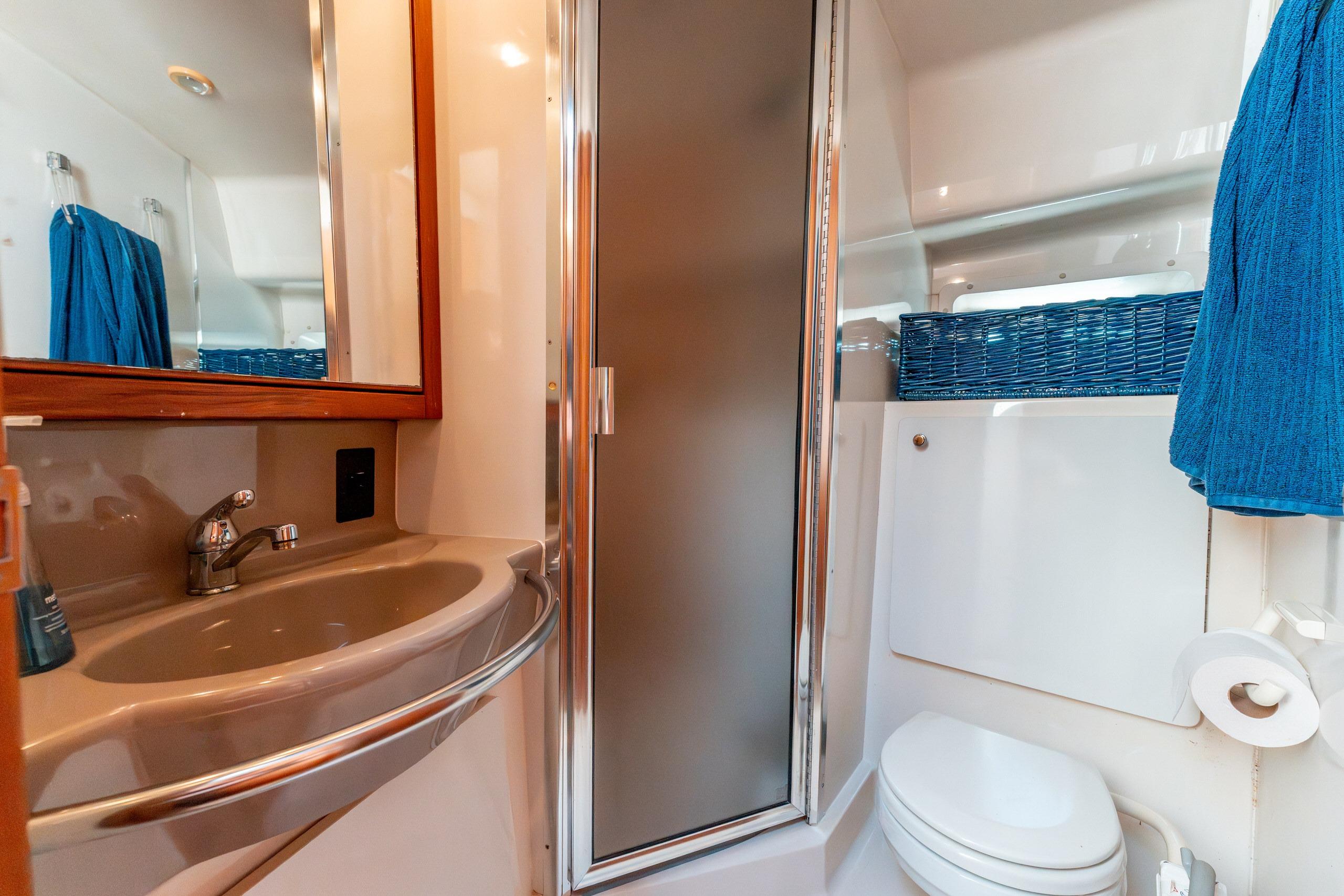 Bathroom interior of 1997 Bayliner 3788 Command Bridge Motoryacht with sink, shower, and toilet.