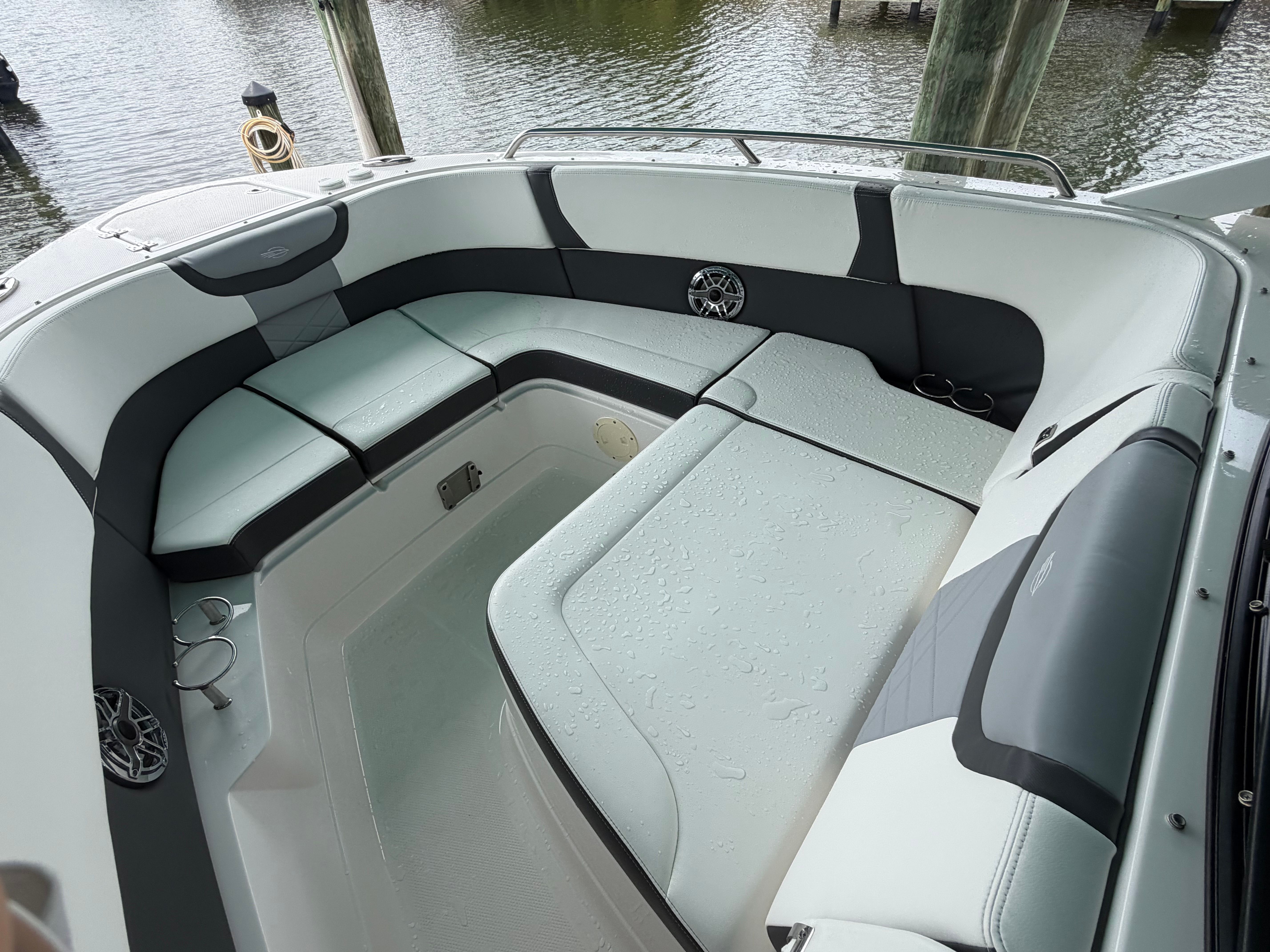 The boat features a spacious seating area with gray and white upholstery.