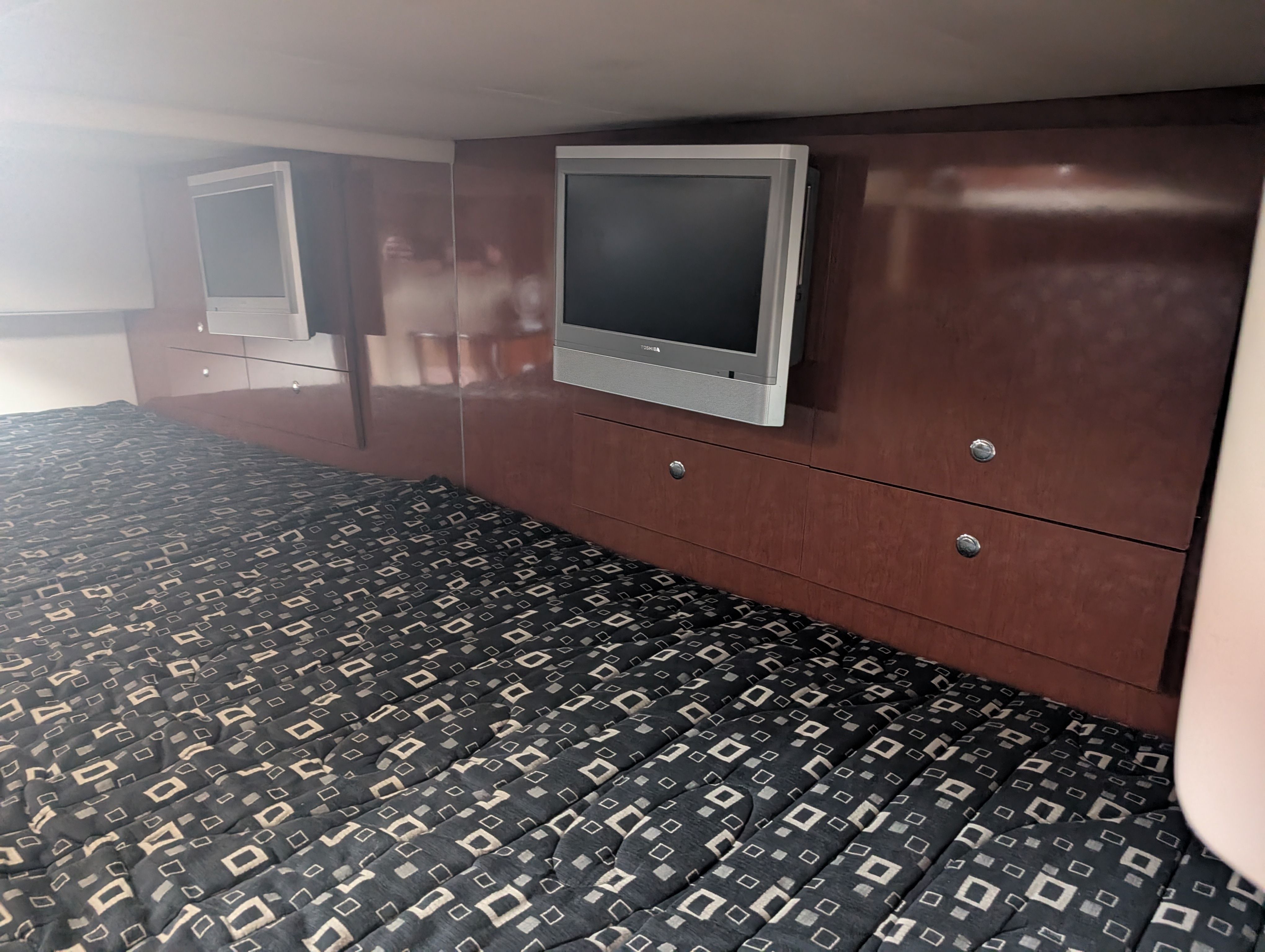 Interior of a 2007 Formula 400 Super Sport with two TVs and patterned carpet.