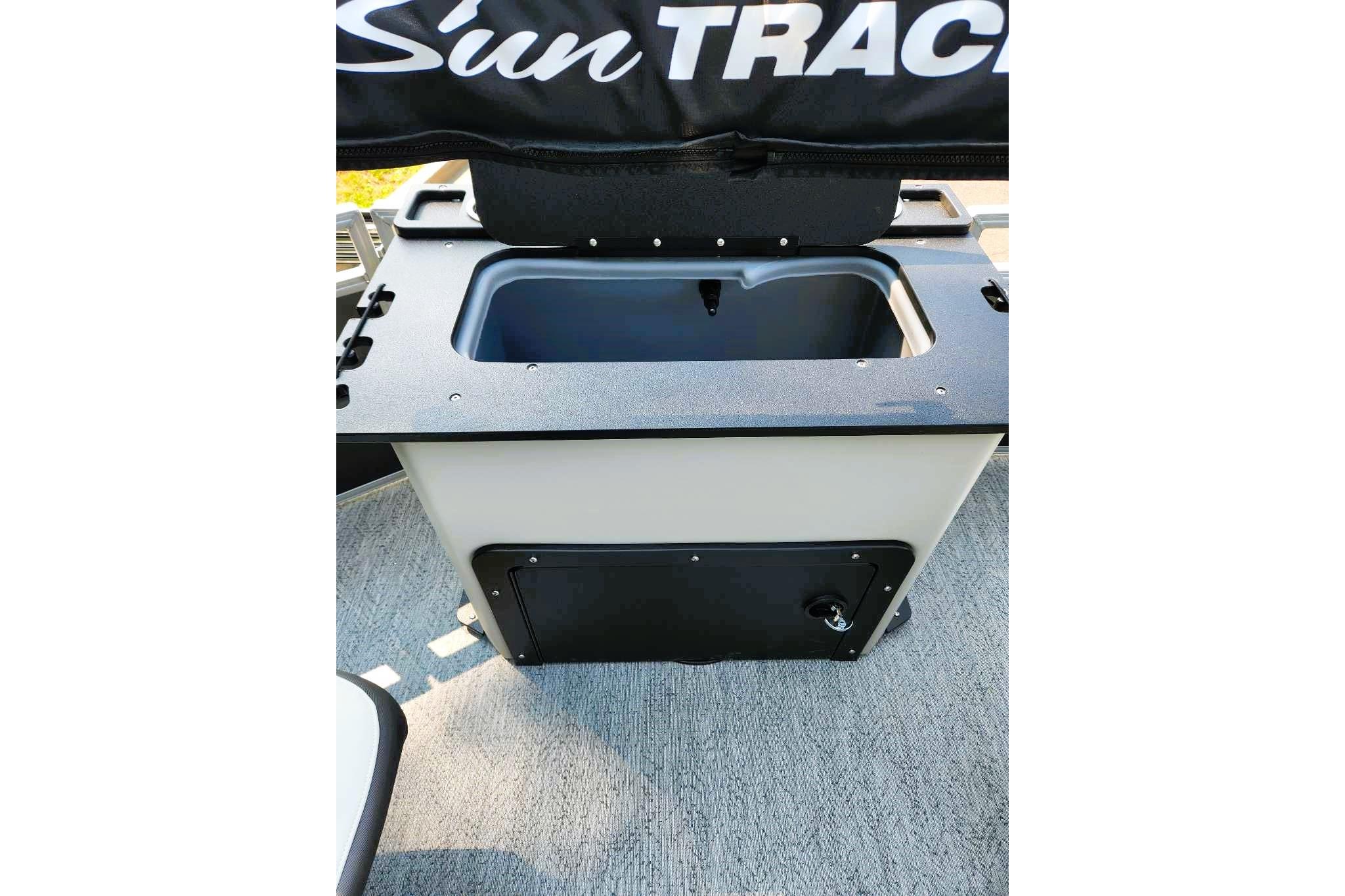 2026 Sun Tracker Fishin' Barge 20 DLX livewell compartment with black lid and storage.