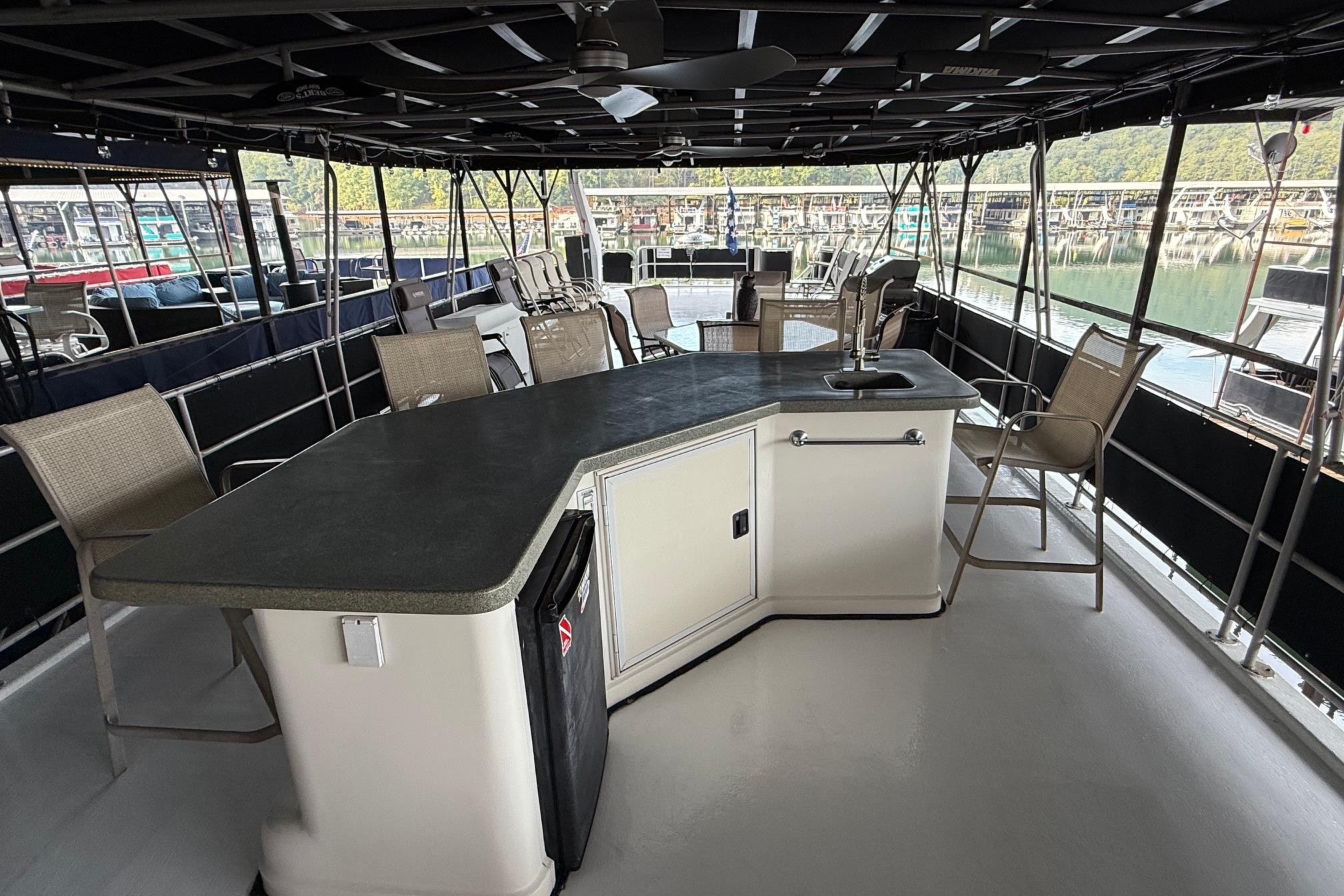 Spacious deck of a 1998 Sumerset 16x76 houseboat with seating and bar area.