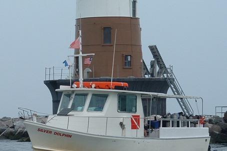 1980 Thompson Passenger and Dive Trawler near lighthouse, named "Silver Dolphin."