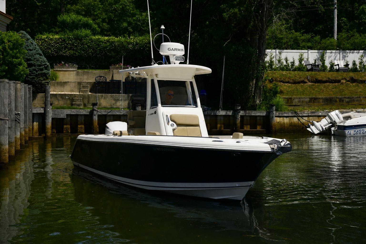 2020 Pursuit C 238 Center Console boat docked in a serene waterfront setting.