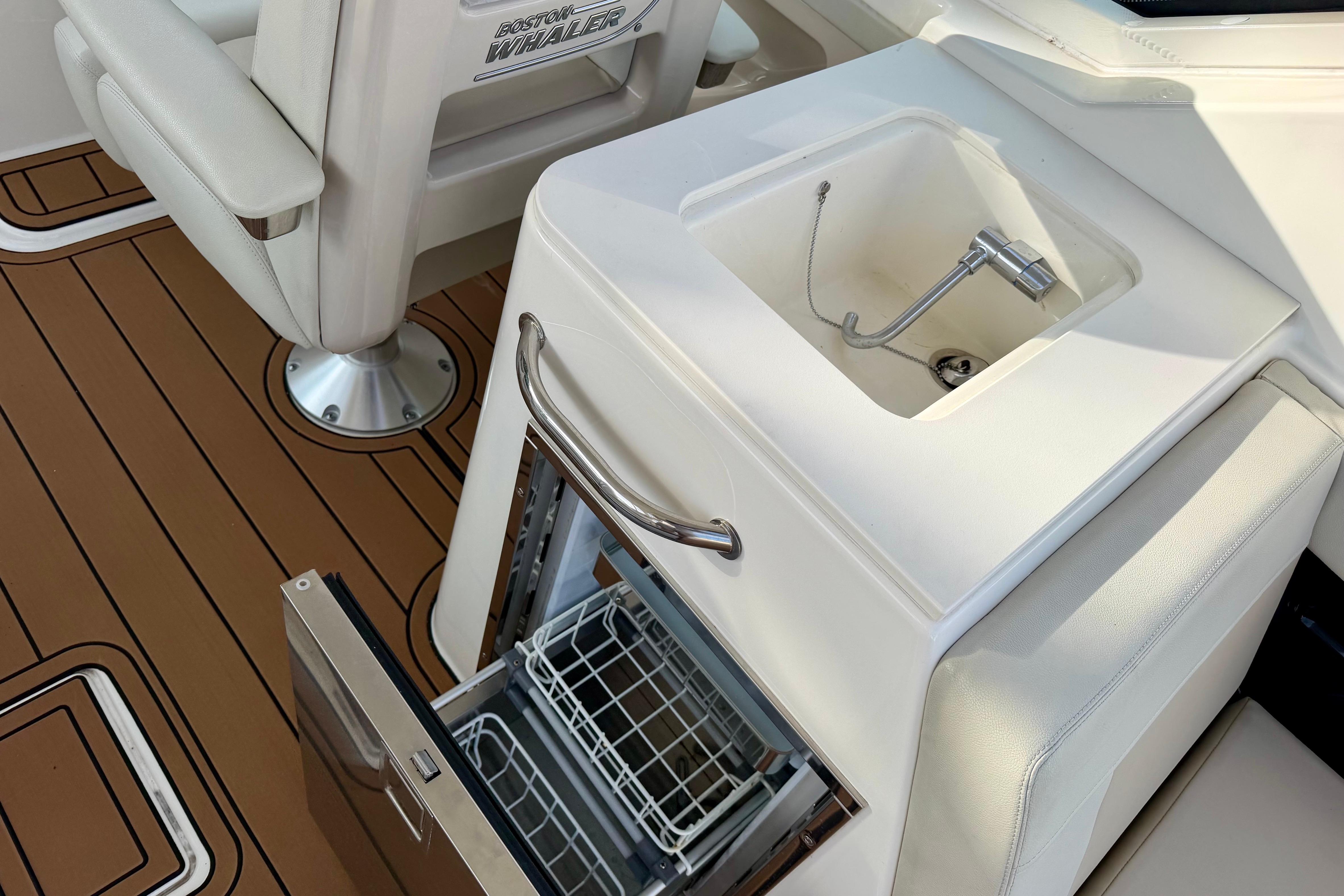 Boston Whaler 280 Vantage 2022 boat interior with sink and open storage compartment.