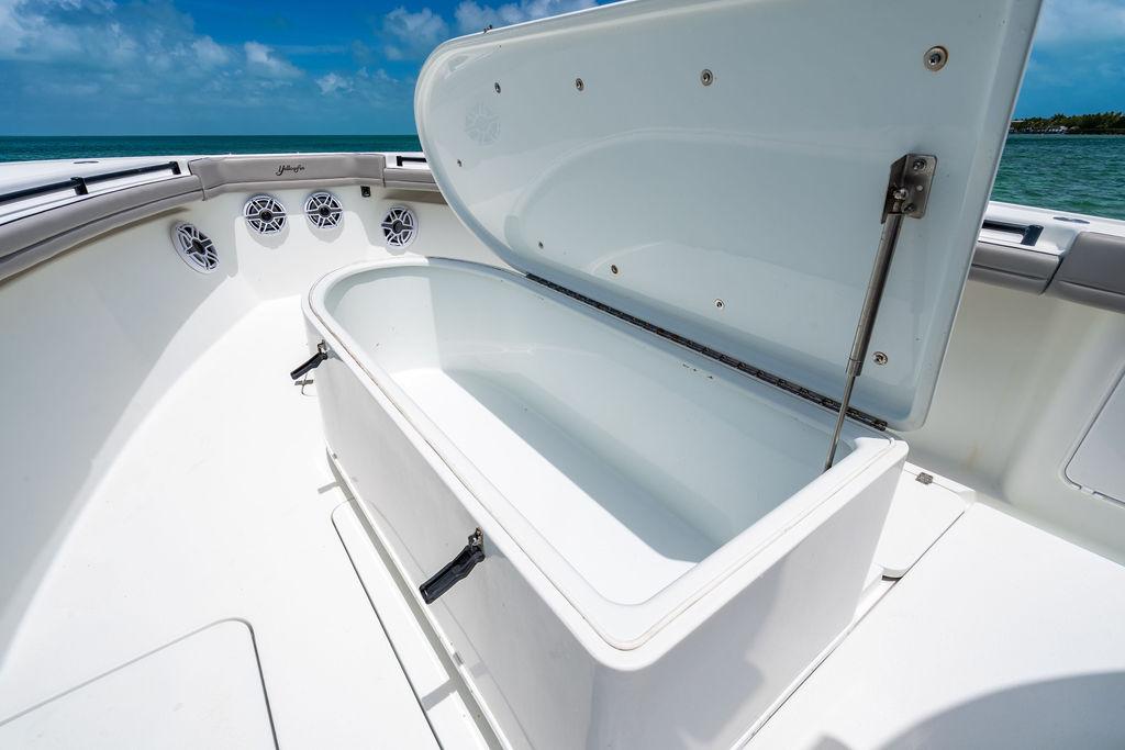 2015 Yellowfin CC boat with open storage compartment, ocean view in background.
