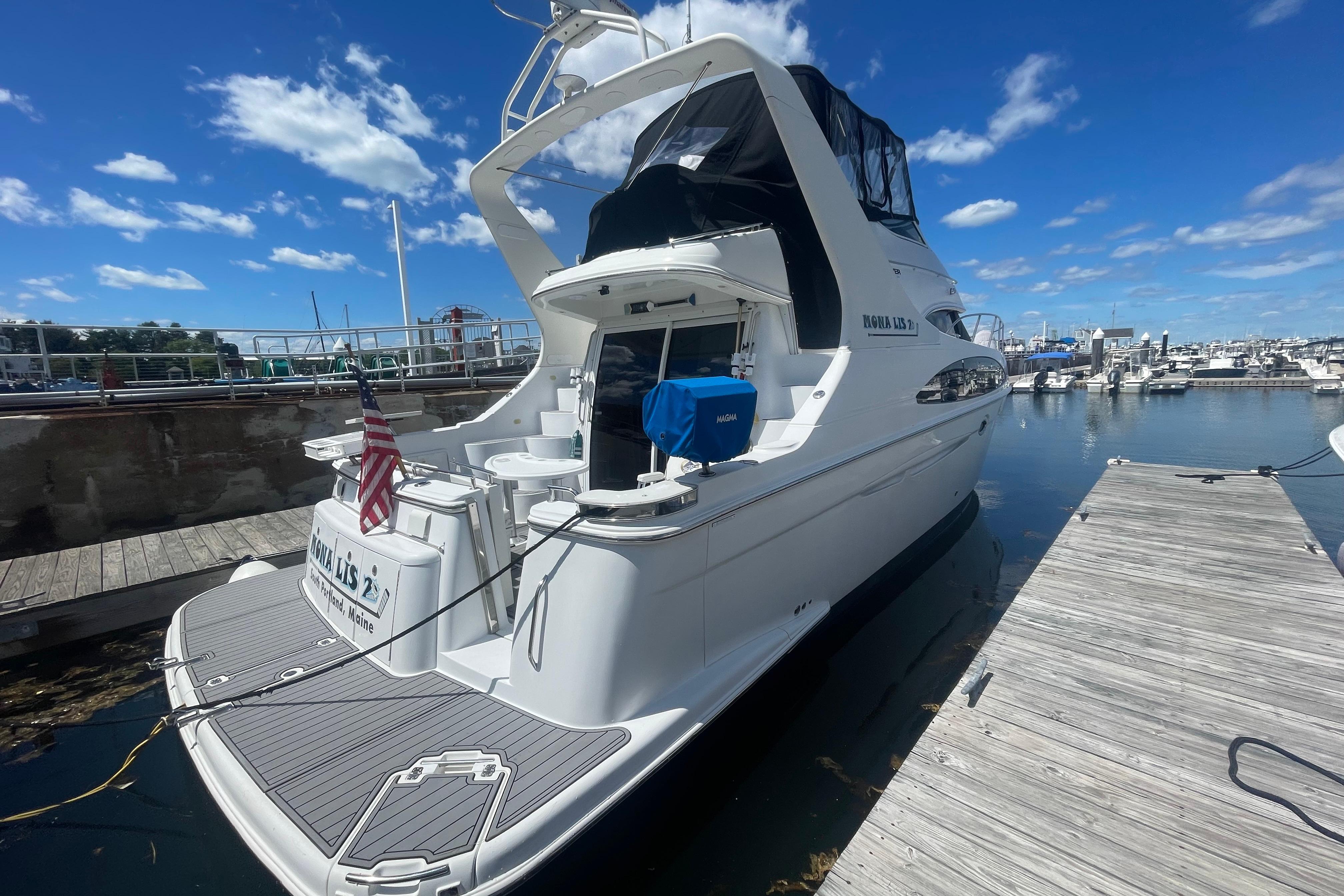 2002 Carver 410 Sport Sedan yacht docked at marina under clear blue sky.