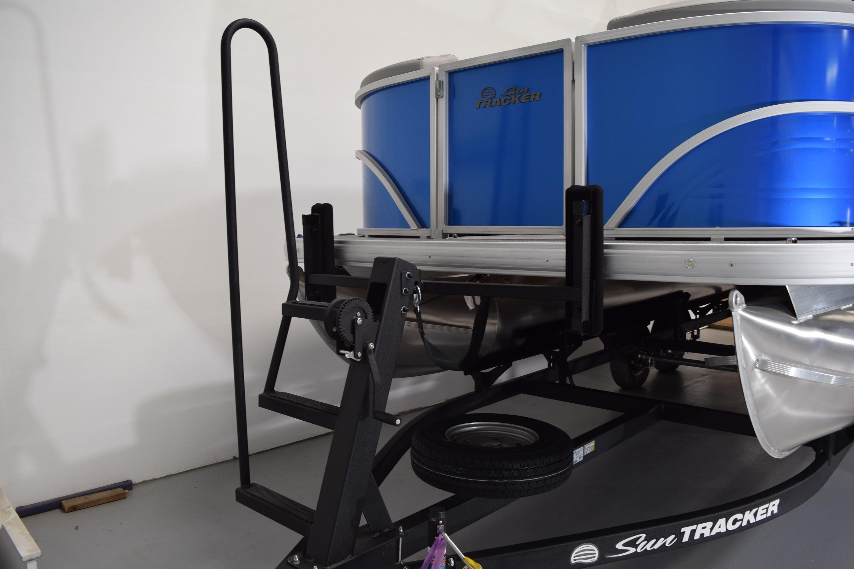 2026 Sun Tracker Party Barge 20 DLX pontoon boat on trailer in garage.