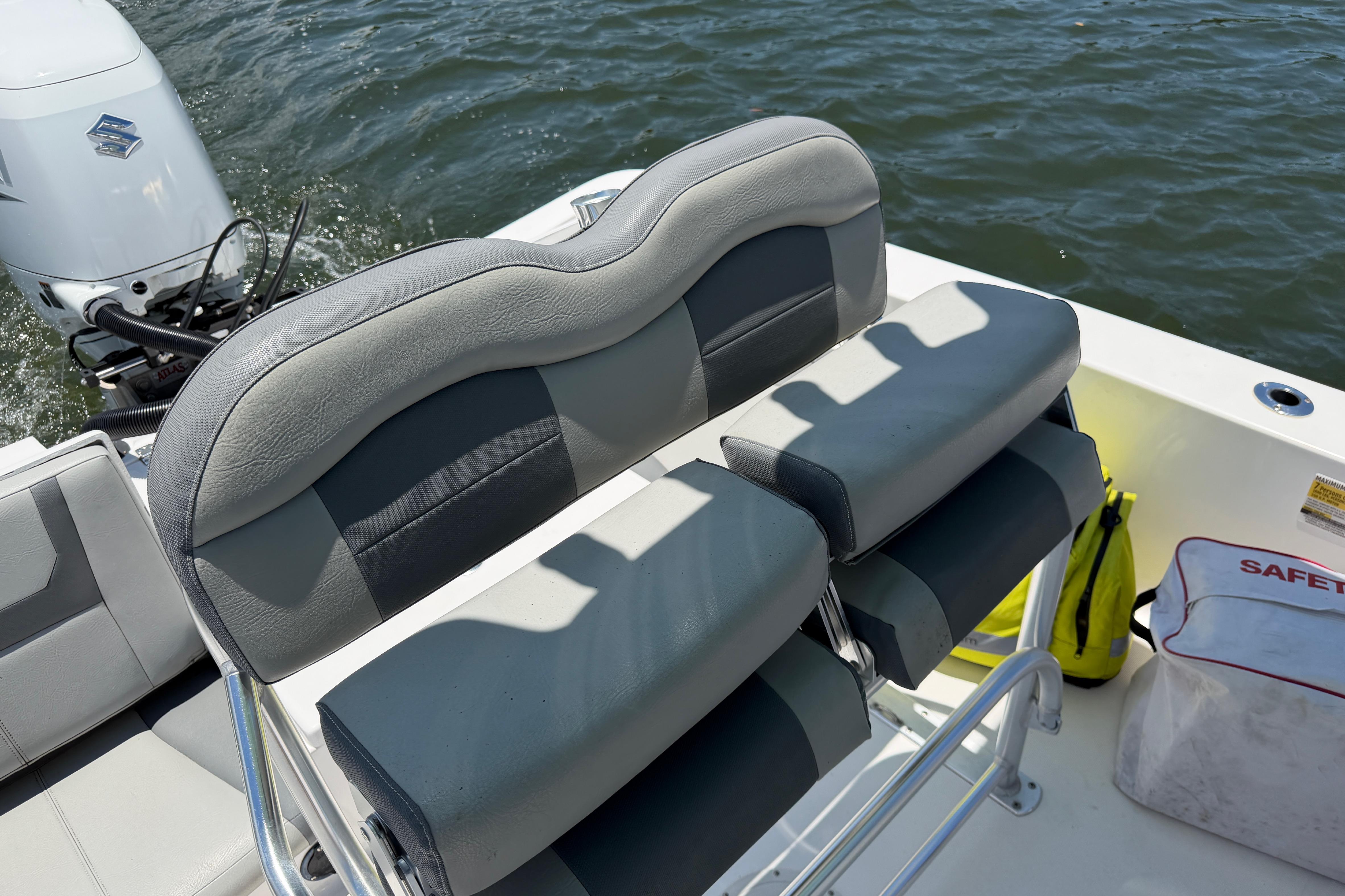 2022 Aquasport 230 Pro Bay boat interior with cushioned seating and Suzuki outboard motor.