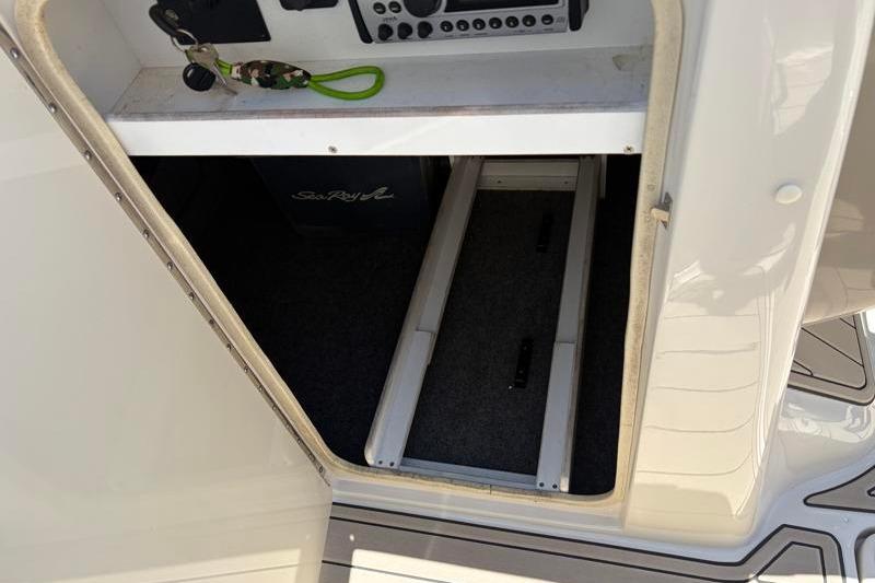 Storage compartment on a 2007 Sea Ray 240 Sundeck boat, featuring interior shelving.