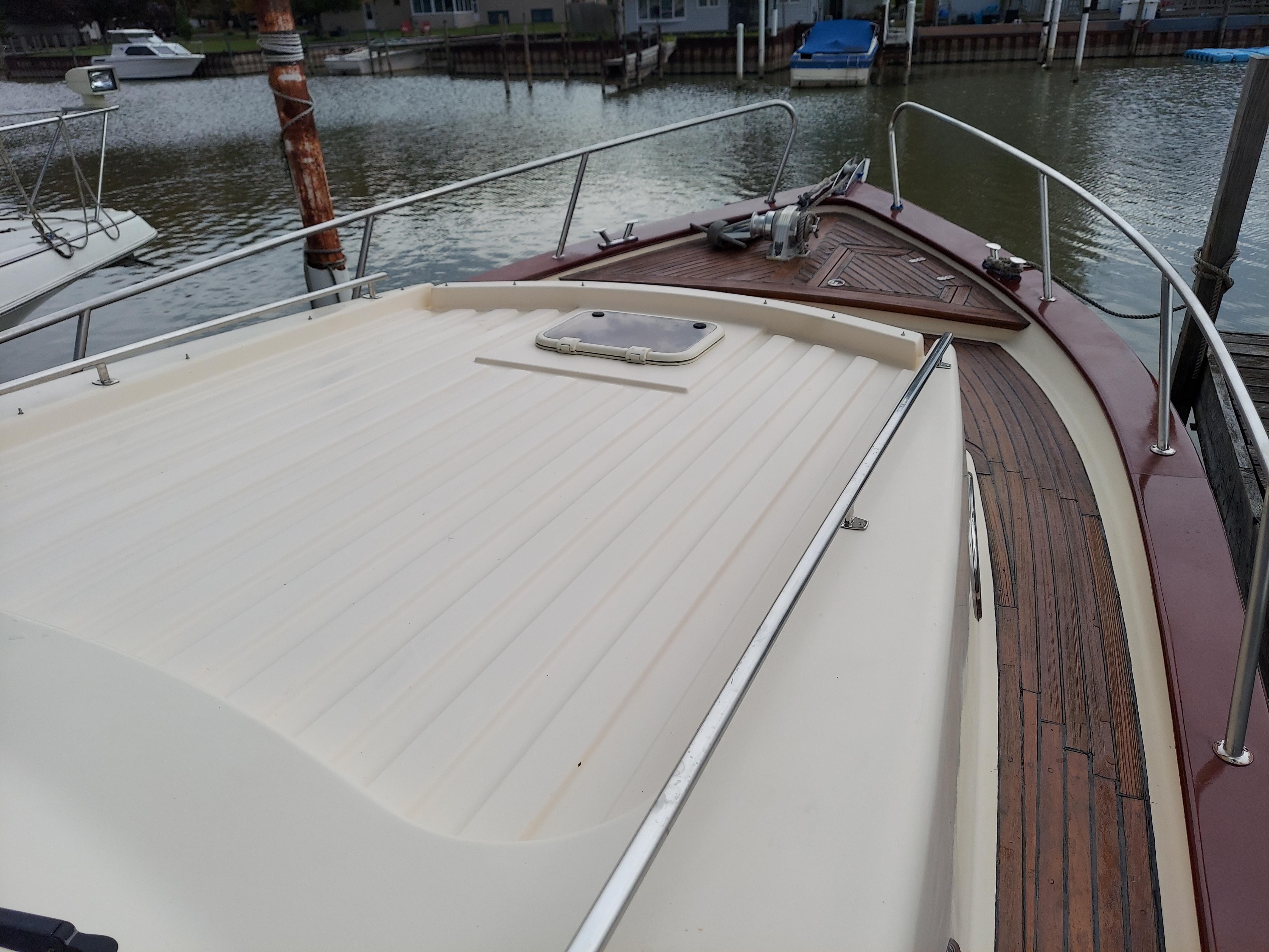 2001 Apreamare 10M Cabinato yacht deck with wooden accents, docked by the water.