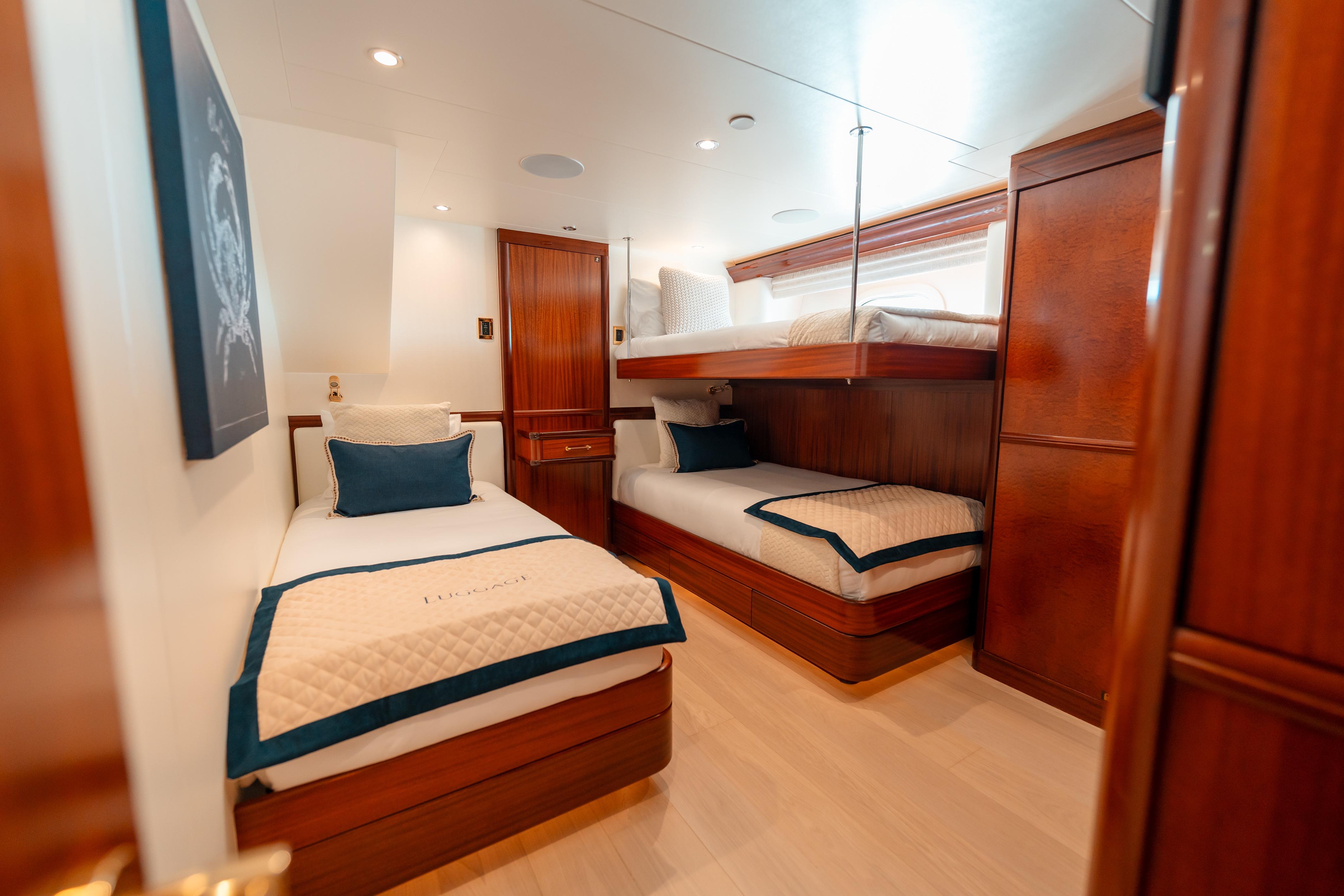 Luxurious cabin interior of 2009 Westport Tri-Deck yacht with twin beds and wooden finishes.