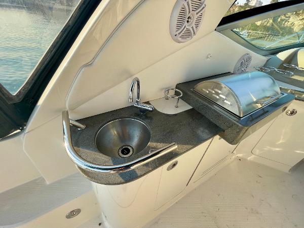 2014 Sea Ray 330 Sundancer yacht kitchenette with sink and covered grill.