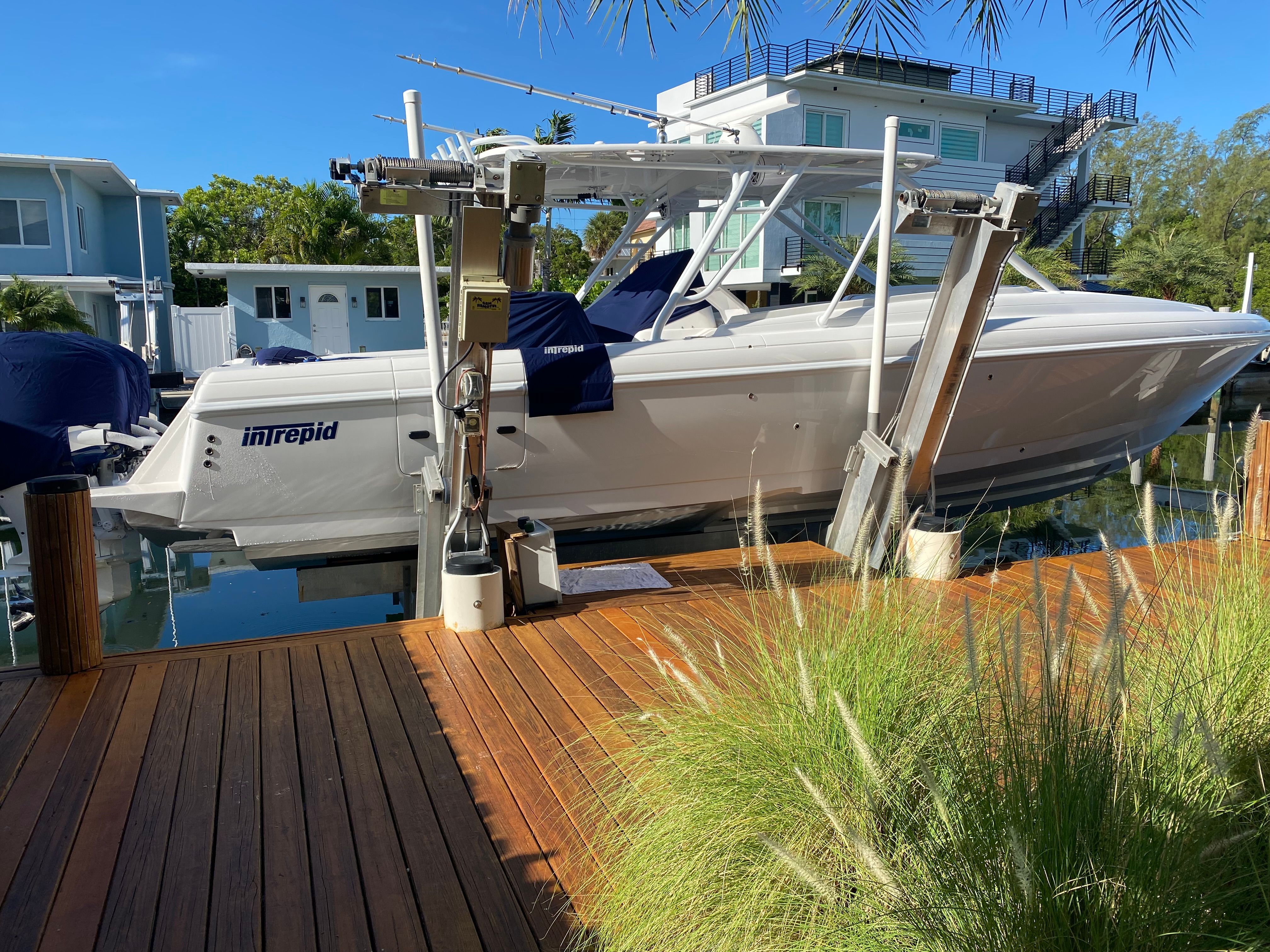 A 2011 Intrepid 37 boat docked at a wooden pier in a calm harbor.