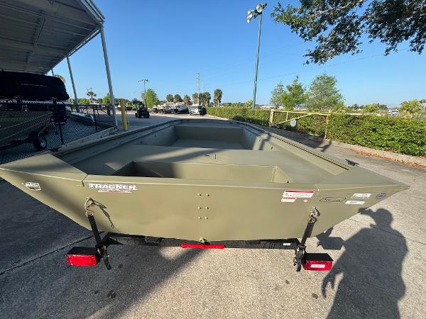 2025 Tracker GRIZZLY 1860 Utility boat on trailer, parked outdoors.