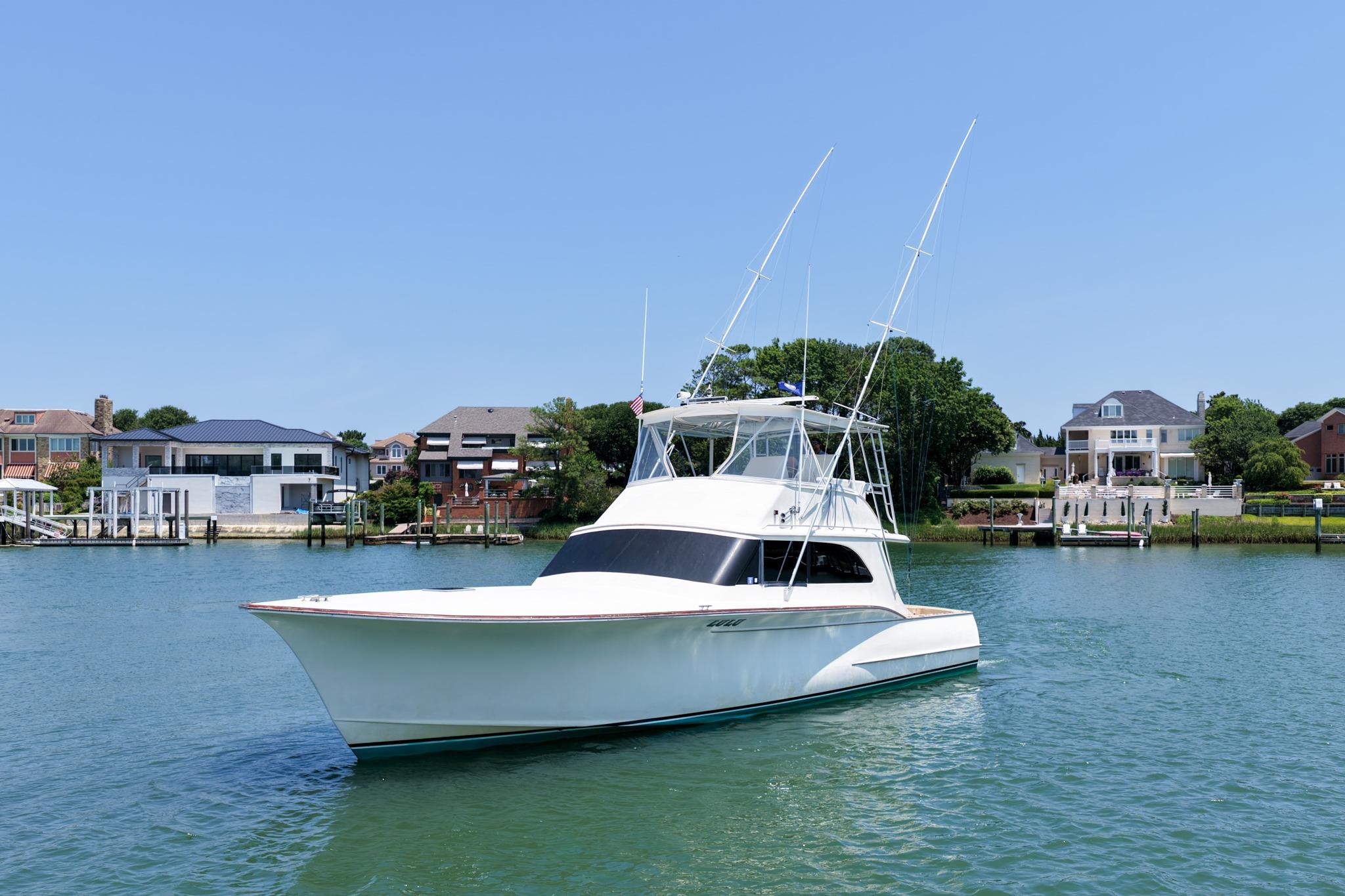 1998 Blackwell Custom Carolina Sportfish yacht on calm water near luxury waterfront homes.