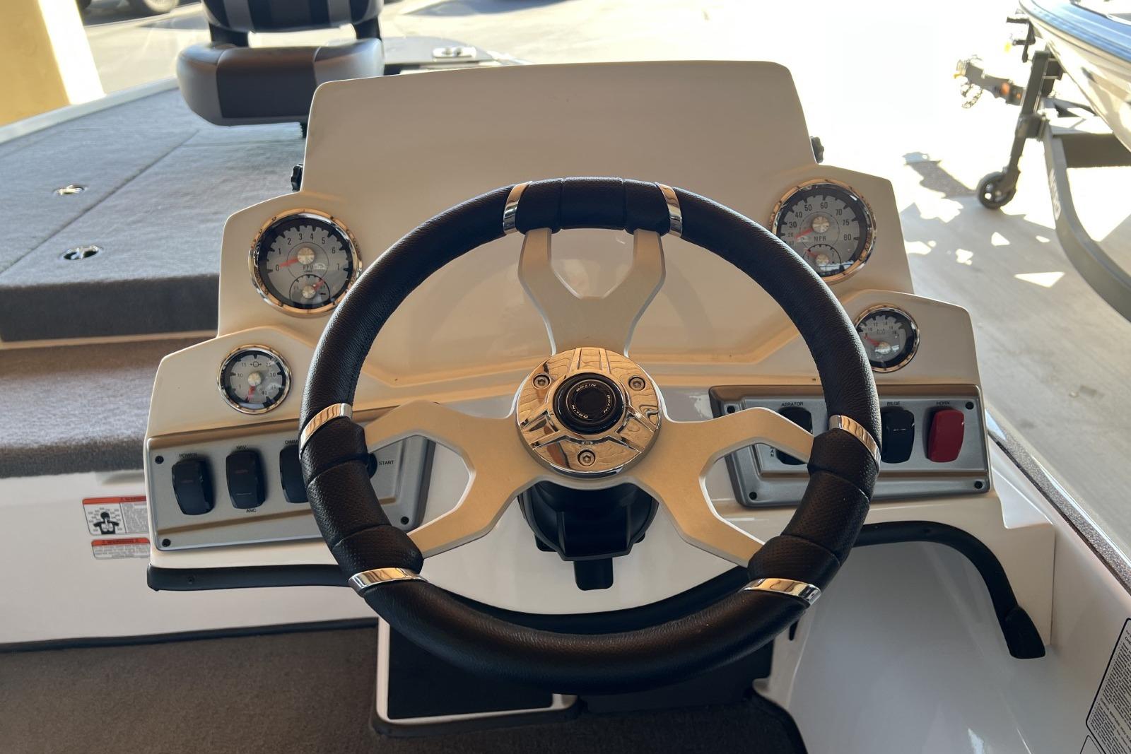 Steering wheel and dashboard of a 2025 Nitro Z19 boat, featuring gauges and controls.