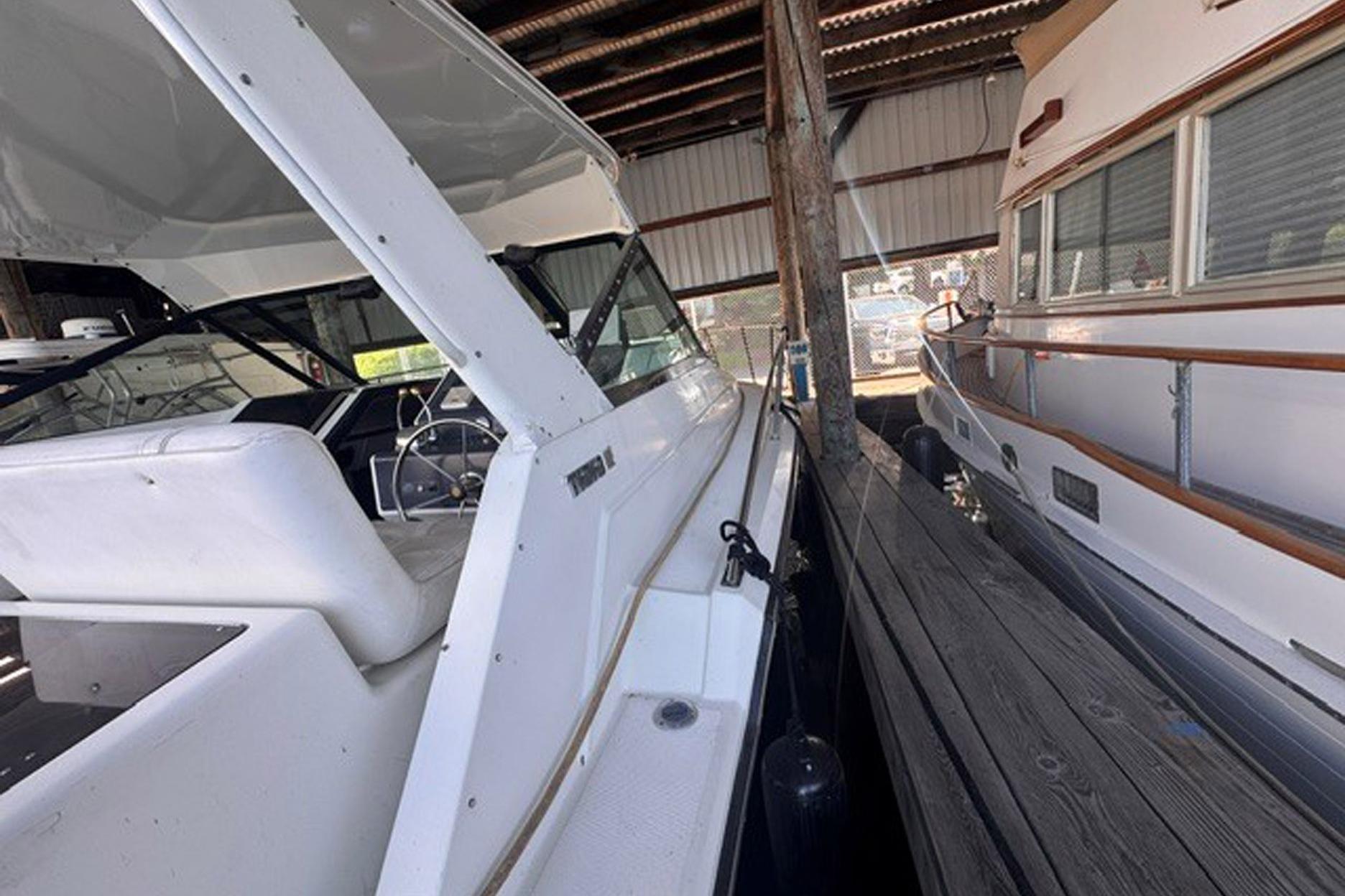 1988 Tiara Yachts 3300 Open docked in a covered marina, side view.