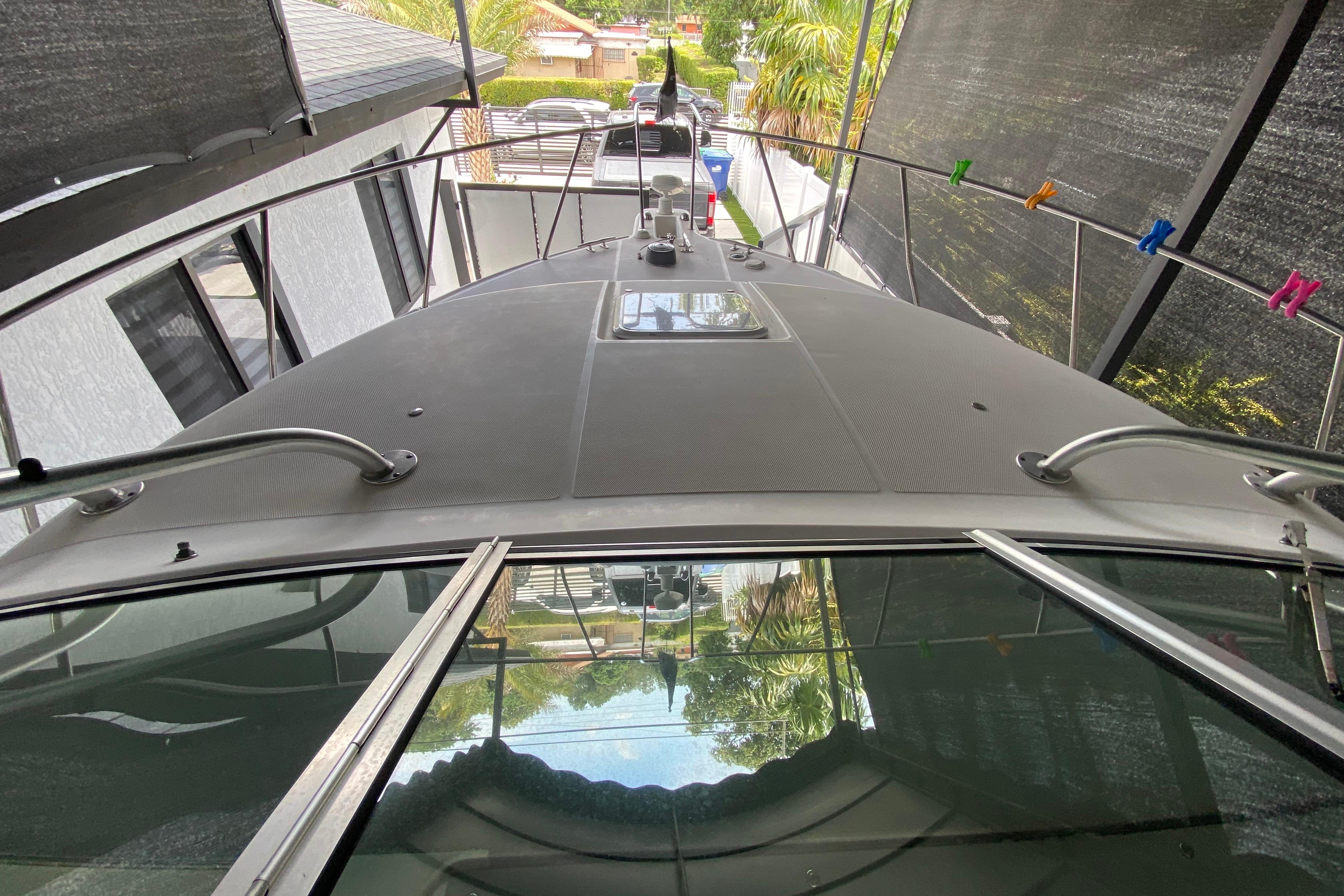 2005 Wellcraft 290 Coastal boat under canopy, viewed from above, with surrounding greenery.