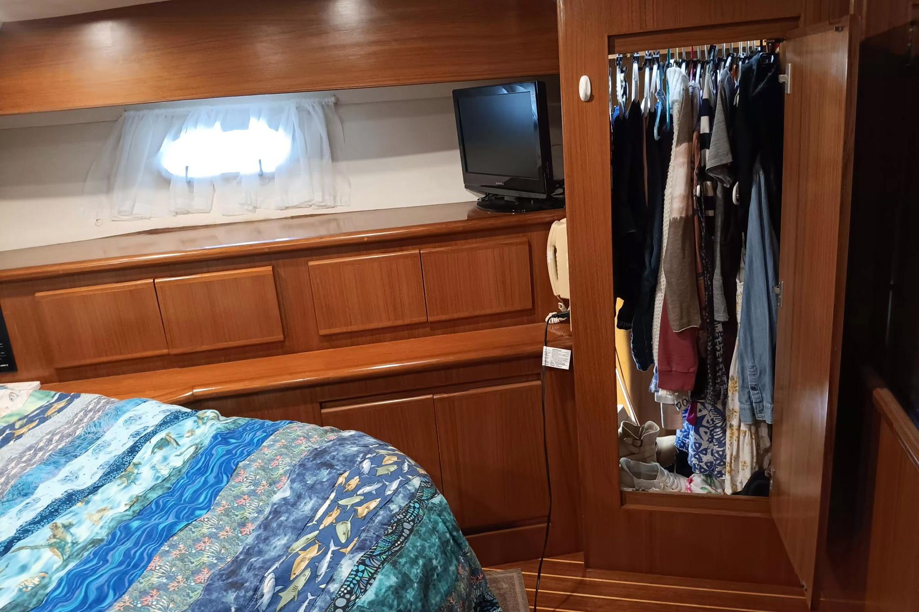 Cozy cabin interior of 1996 Novatec 50 Islander Cockpit with wood paneling and closet.
