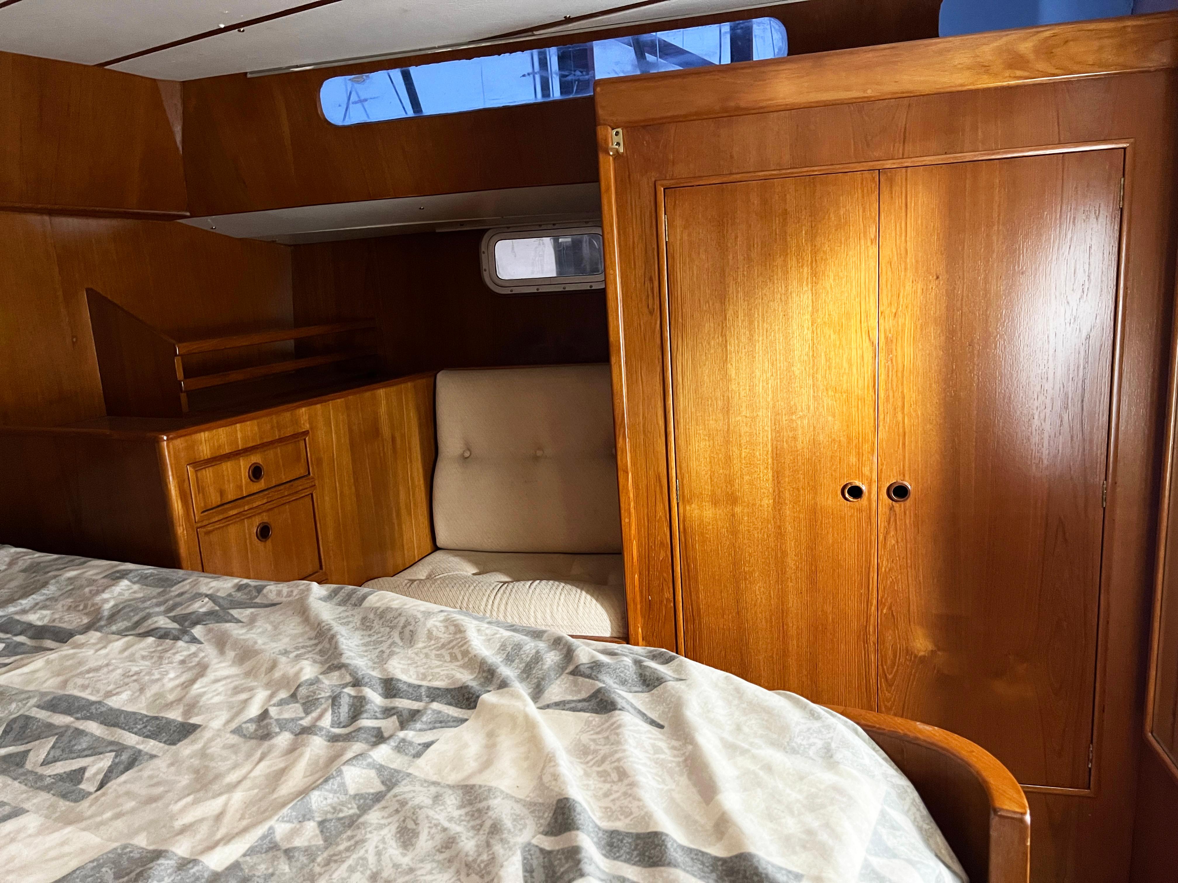 Interior of 1987 Oyster 46.5 yacht with wooden cabinetry and cozy seating area.