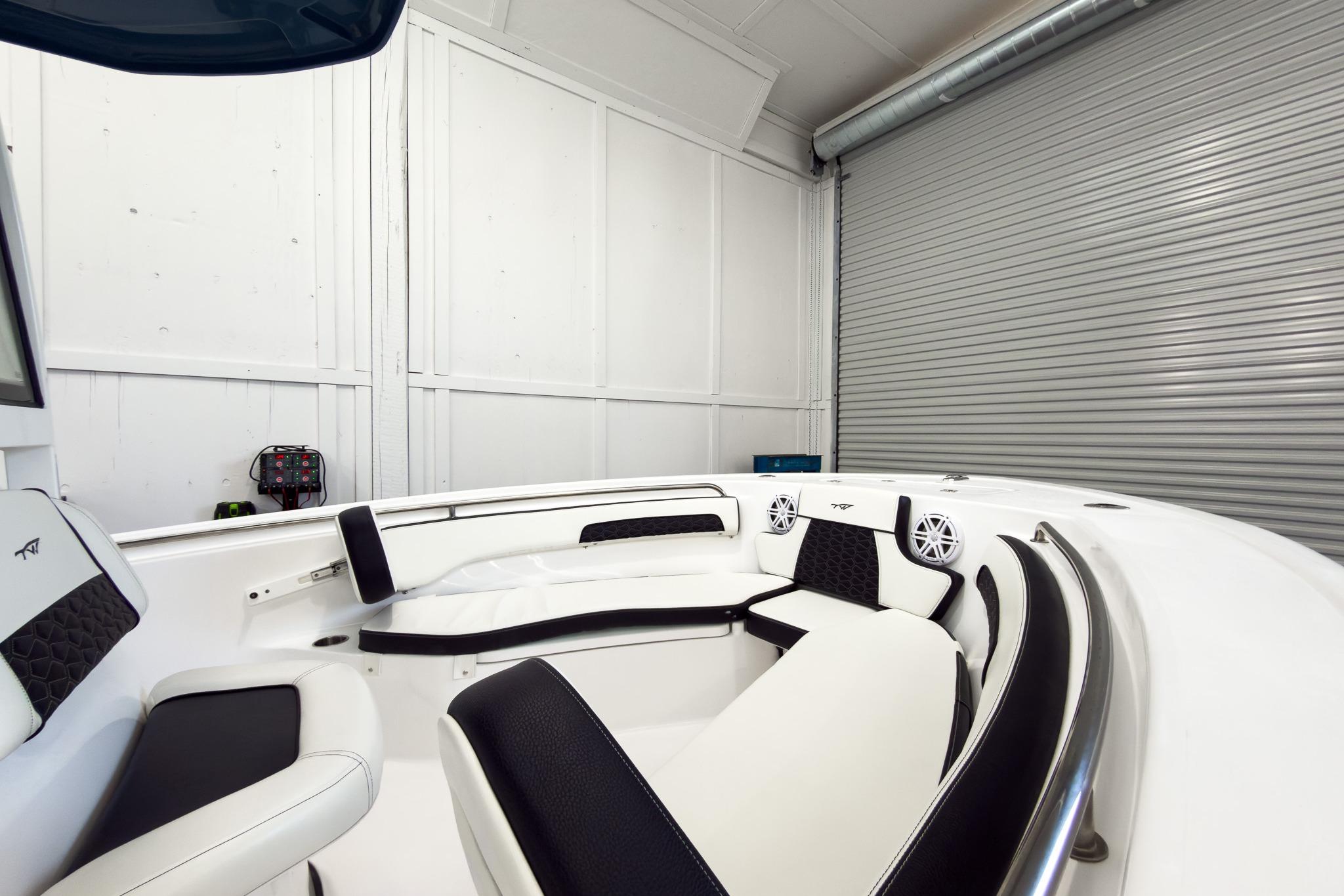 The image shows the interior of a 2026 Tidewater 220 LXF boat with white and black seating.
