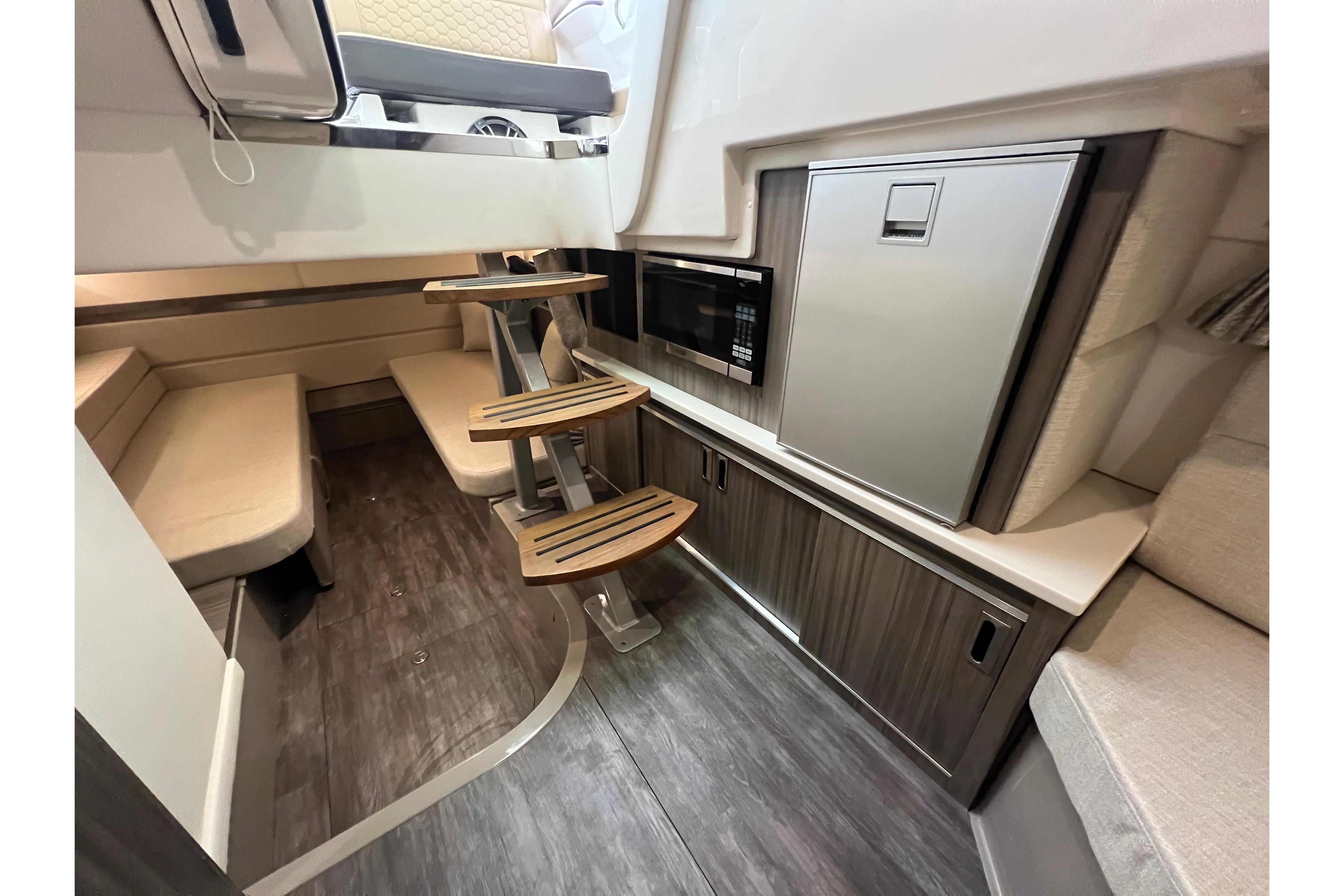 Interior of 2024 Sea Ray Sundancer 320 yacht with modern kitchenette and seating area.