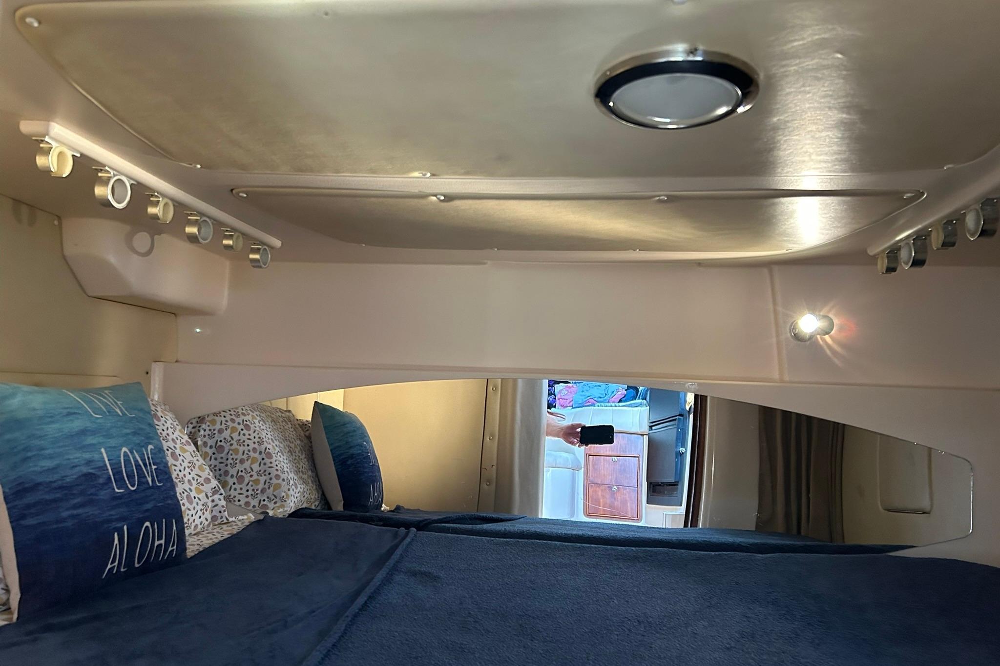 Interior cabin of 2007 Grady-White Express 360 with cozy bedding and ambient lighting.