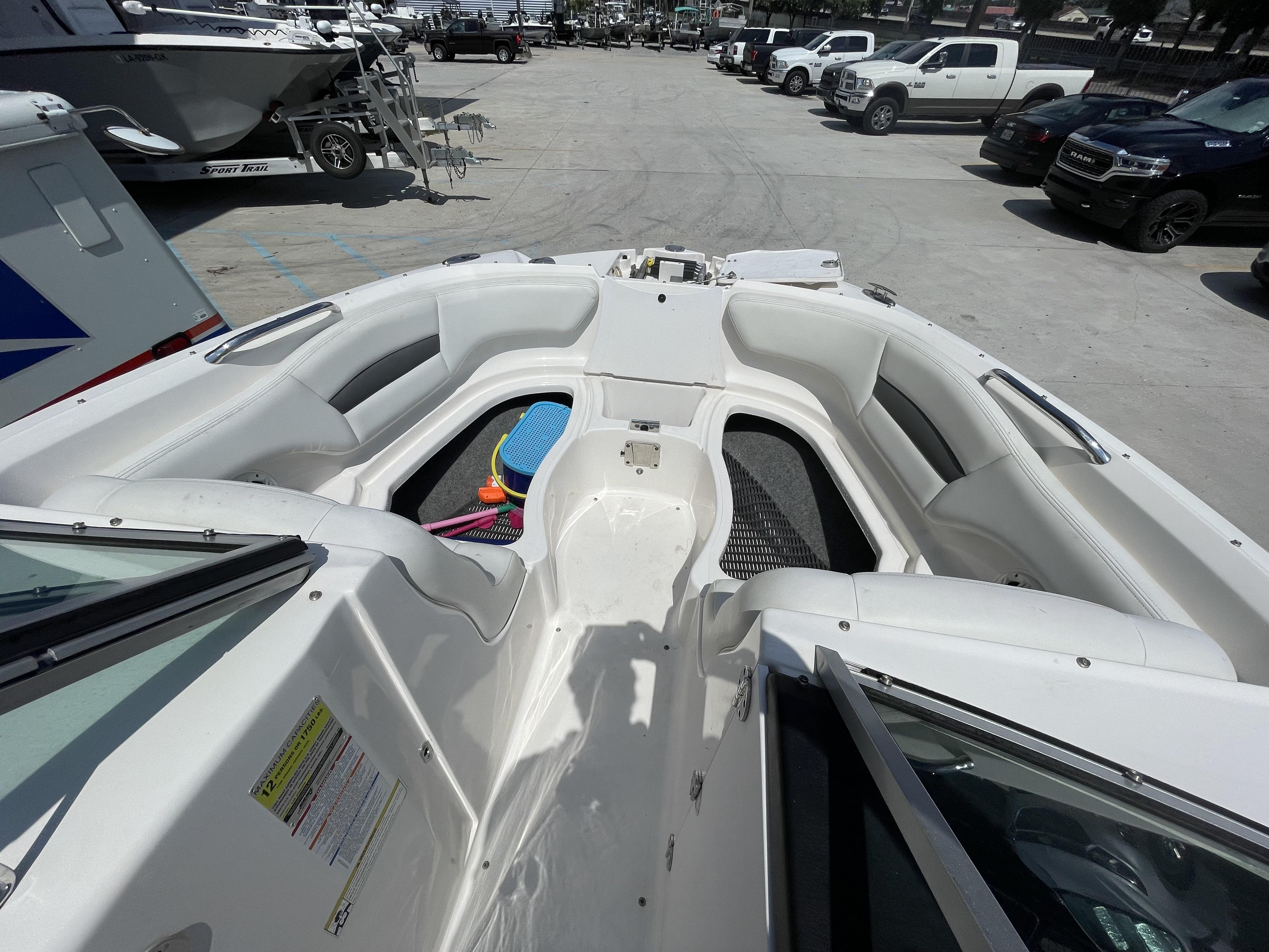 2014 Chaparral Sunesta 224 boat interior with seating and storage, parked in a lot.