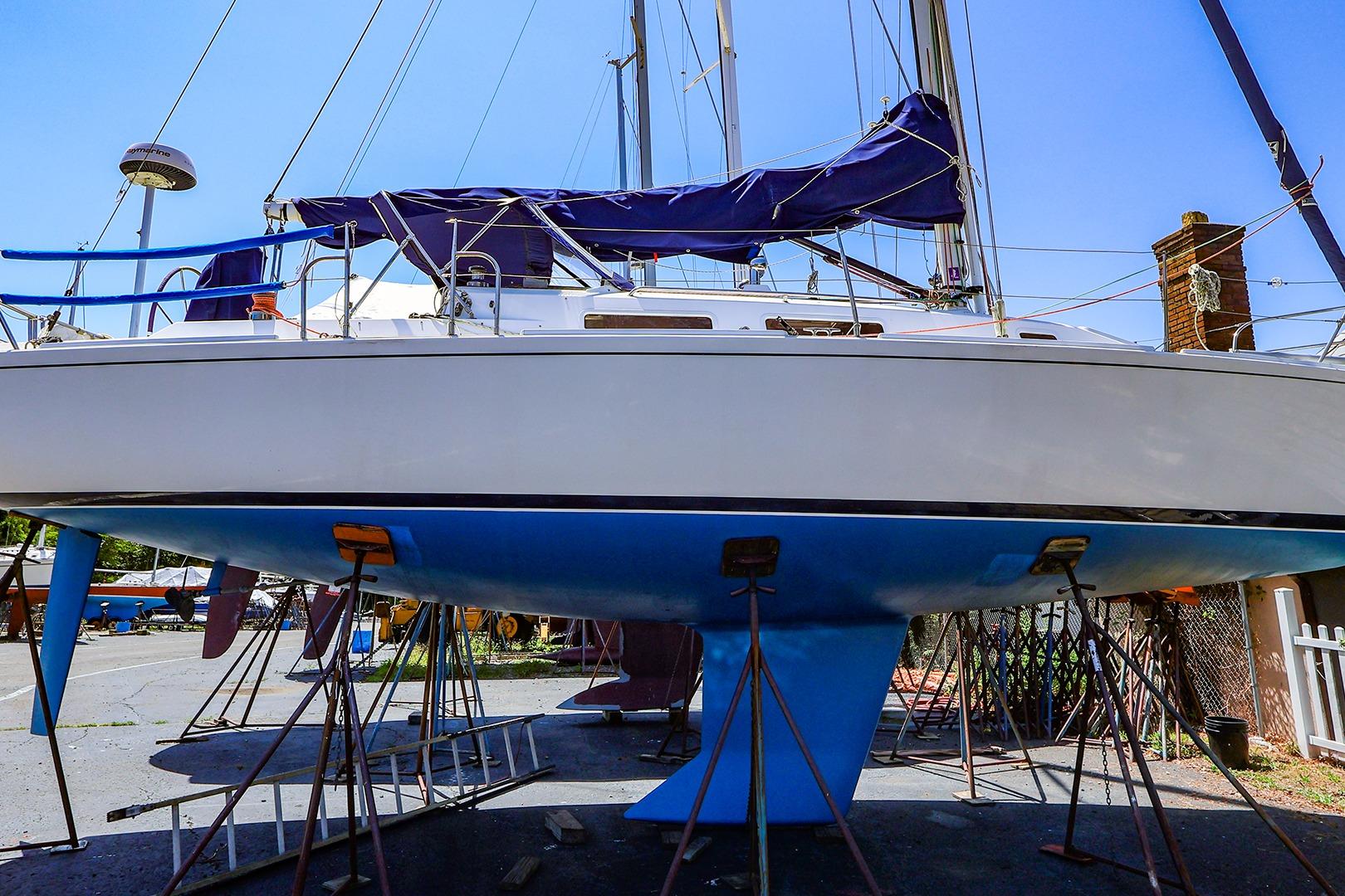 2001 J Boats J/32 sailboat on stands, undergoing maintenance in a boatyard.