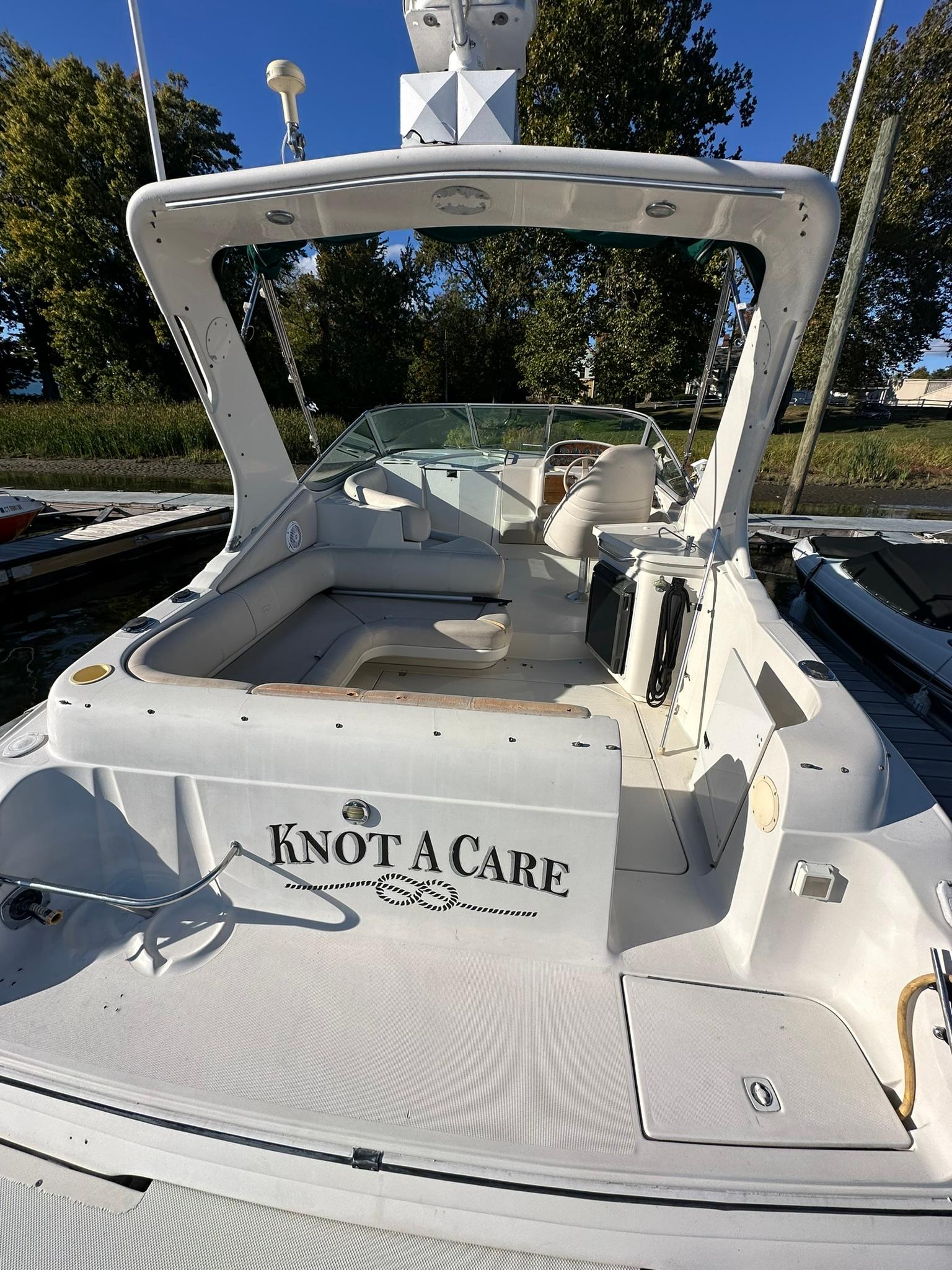 1997 Regal 292 Commodore boat named "Knot A Care" docked in a marina.