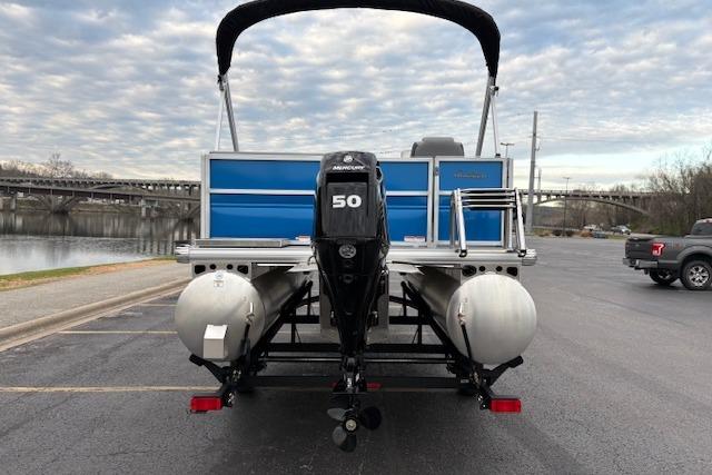 2026 Sun Tracker Party Barge 16 DLX pontoon boat with Mercury 50 engine, parked near a river.