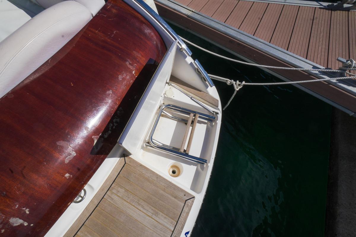 2004 Windy 25 Mirage boat docked, featuring wooden and white seating area.