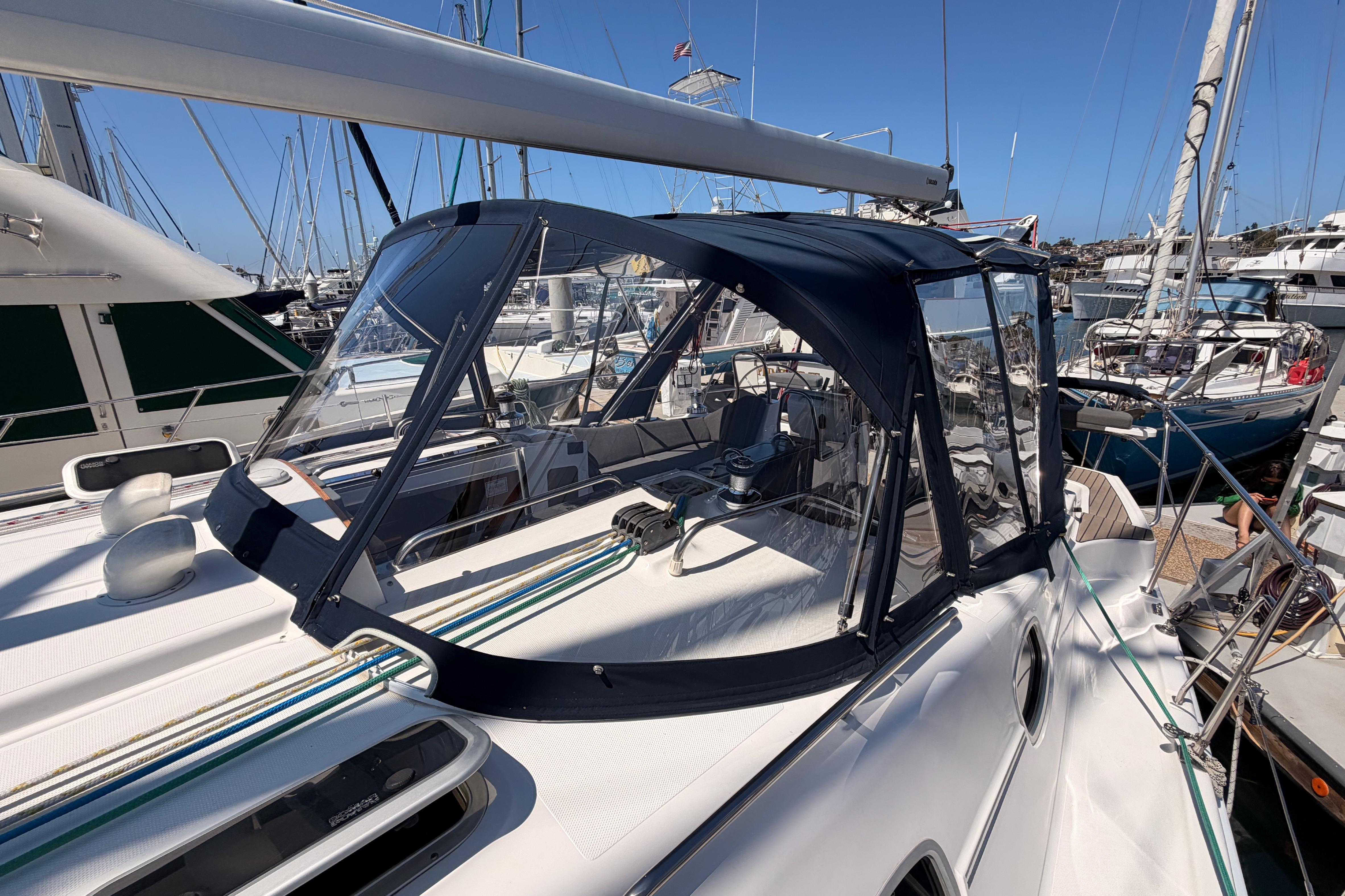 2008 Hunter 45 Deck Salon sailboat docked in marina, featuring sleek design and protective canopy.