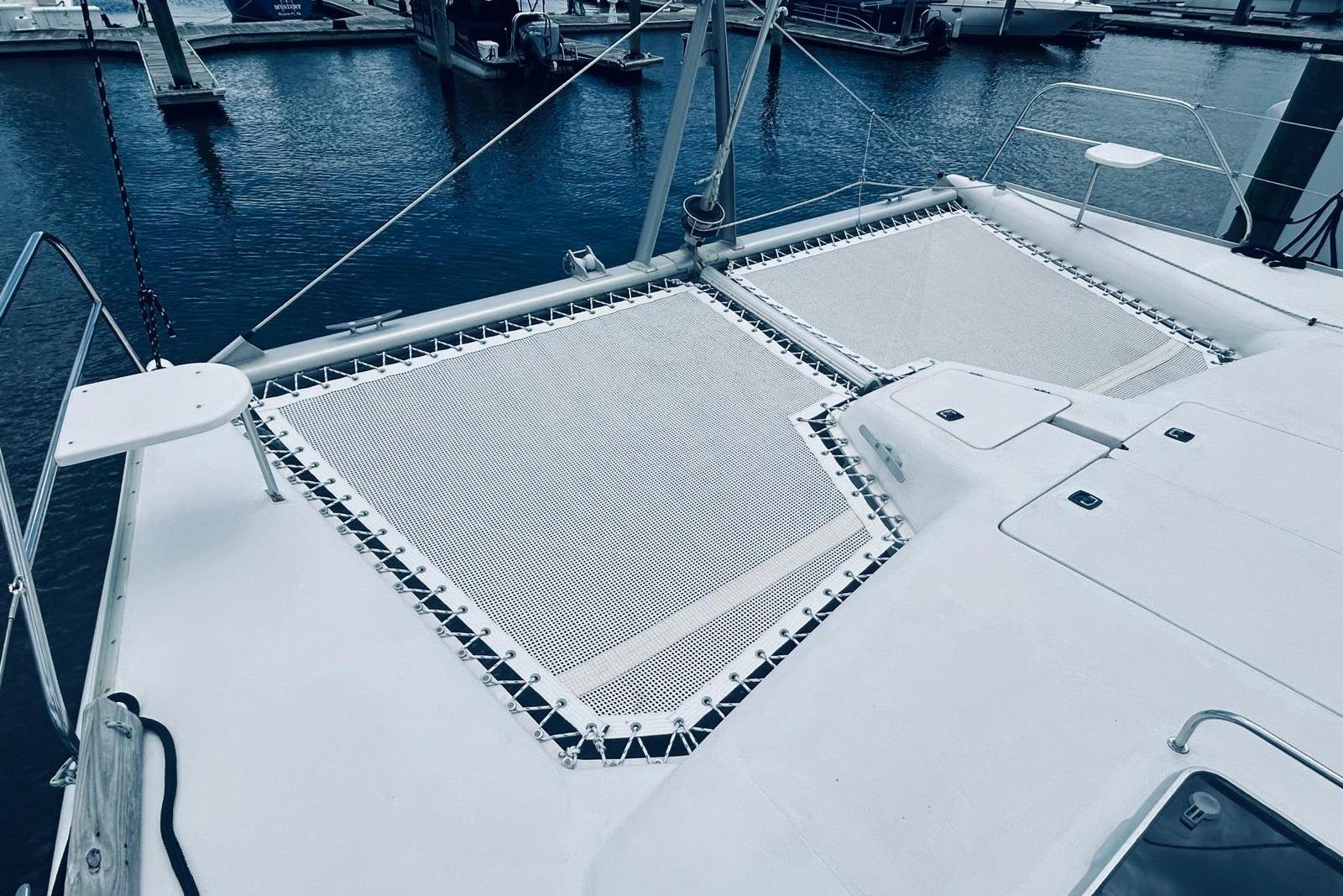 2001 Robertson & Caine Leopard catamaran with netted deck, docked at marina.