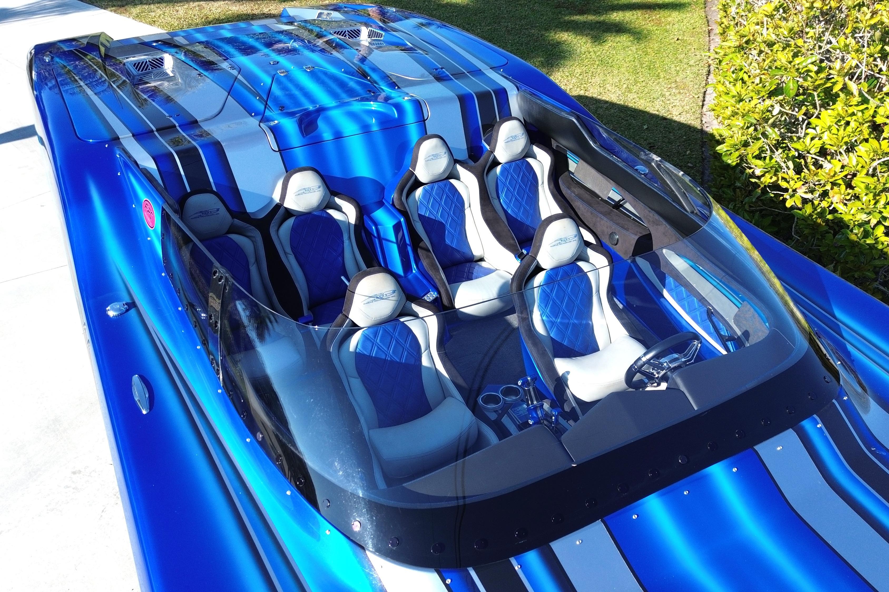2016 MTI 44 RP speedboat with blue and silver design, featuring luxury seating and sleek windshield.