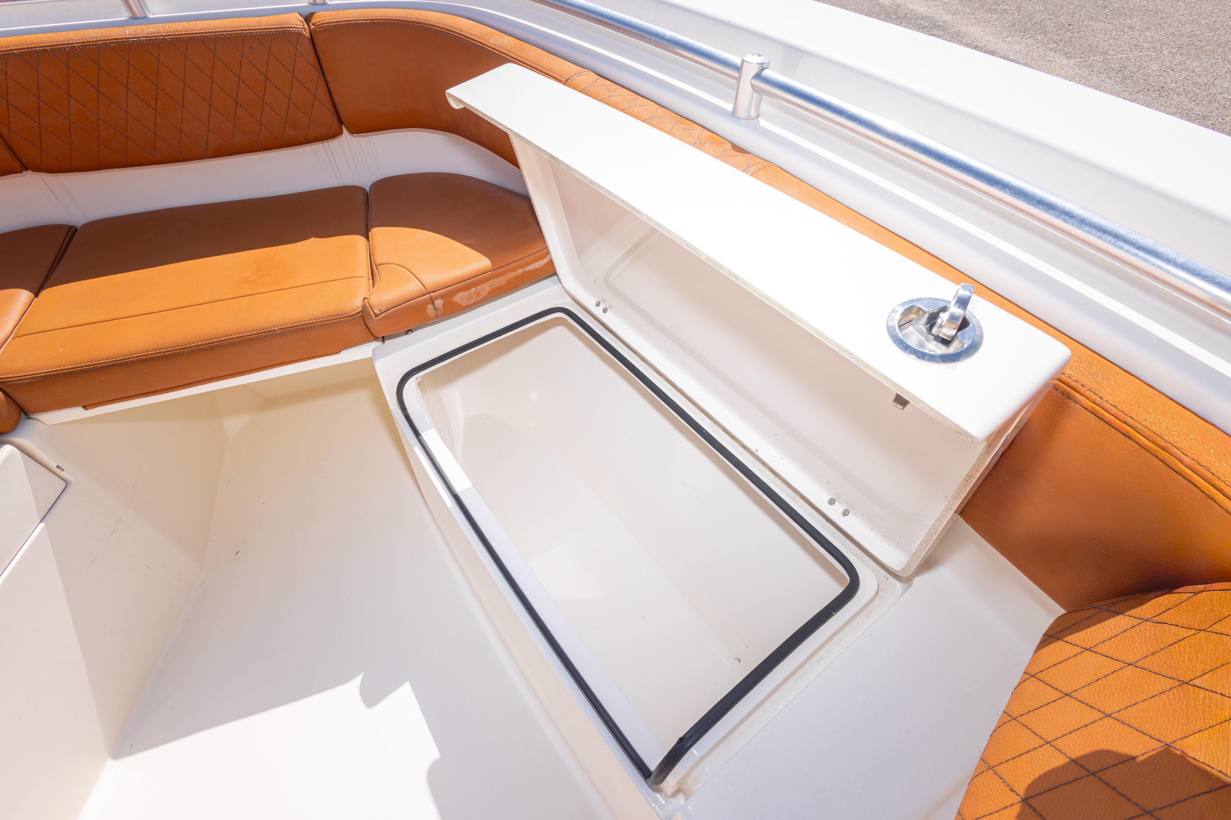 2017 Cobia 261 Center Console boat with tan seating and storage compartment.