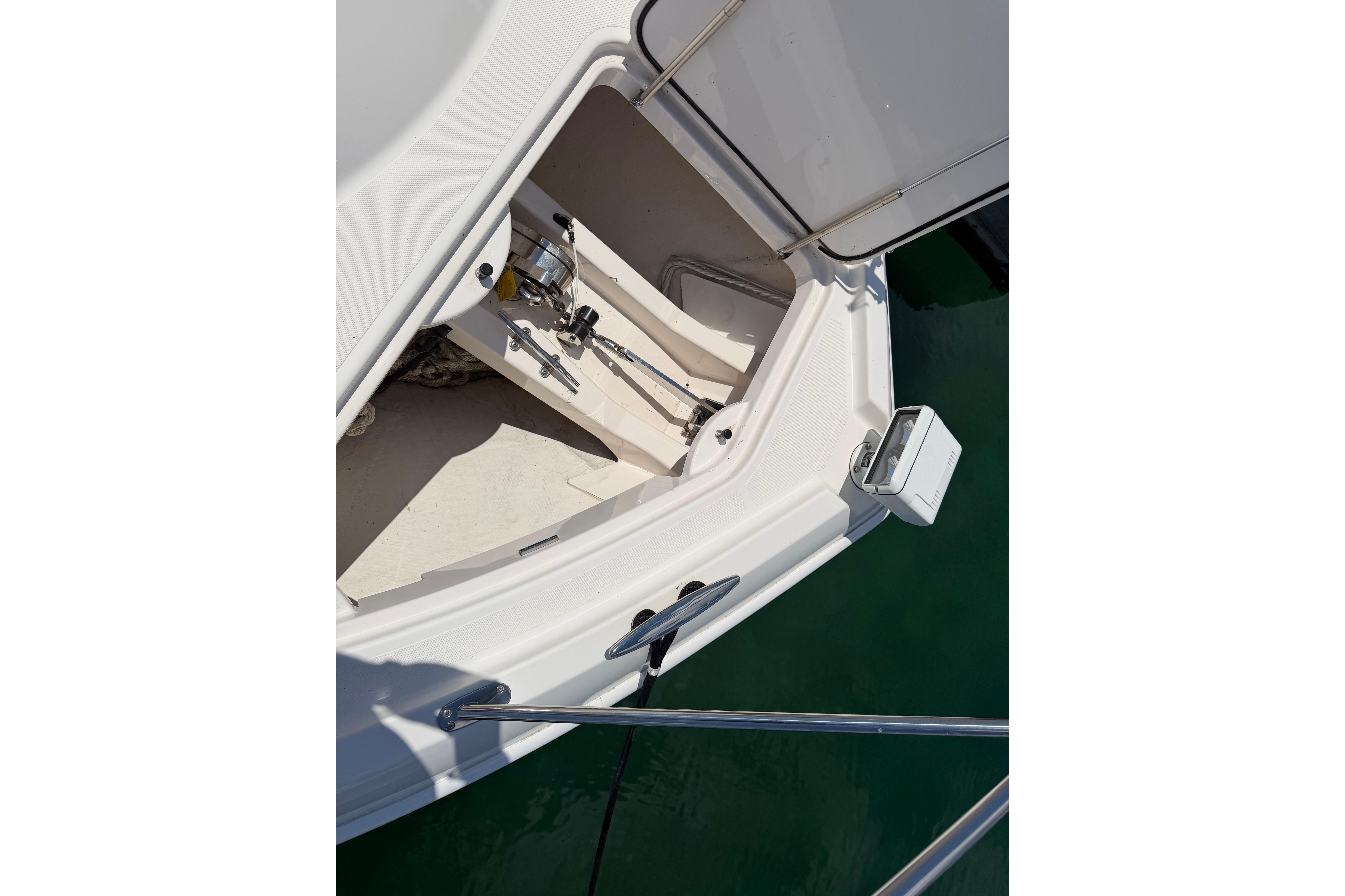 2016 Tiara Yachts C39 Coupe anchor compartment with open hatch, docked on calm water.