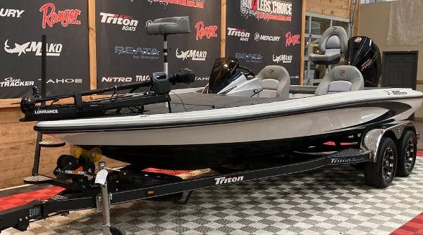2025 Triton 20XP fishing boat on display with trailer in showroom.