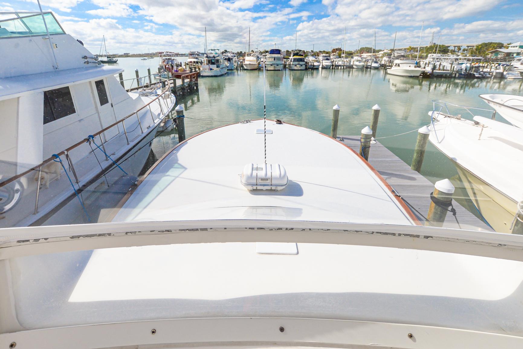 1999 Viking 55 Convertible yacht docked in a marina, surrounded by other boats.
