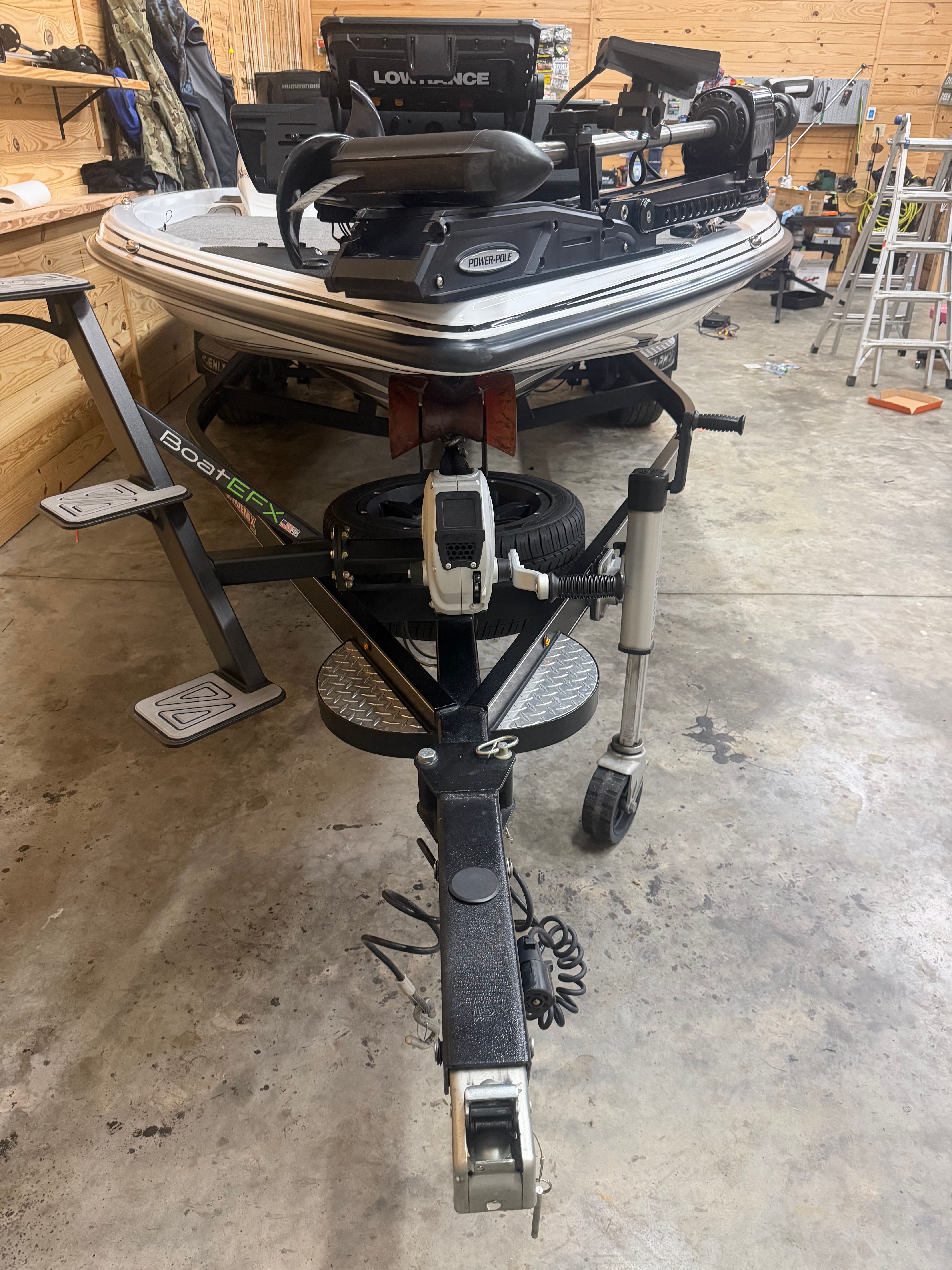 A Phoenix 920 Elite boat on a trailer in a garage.